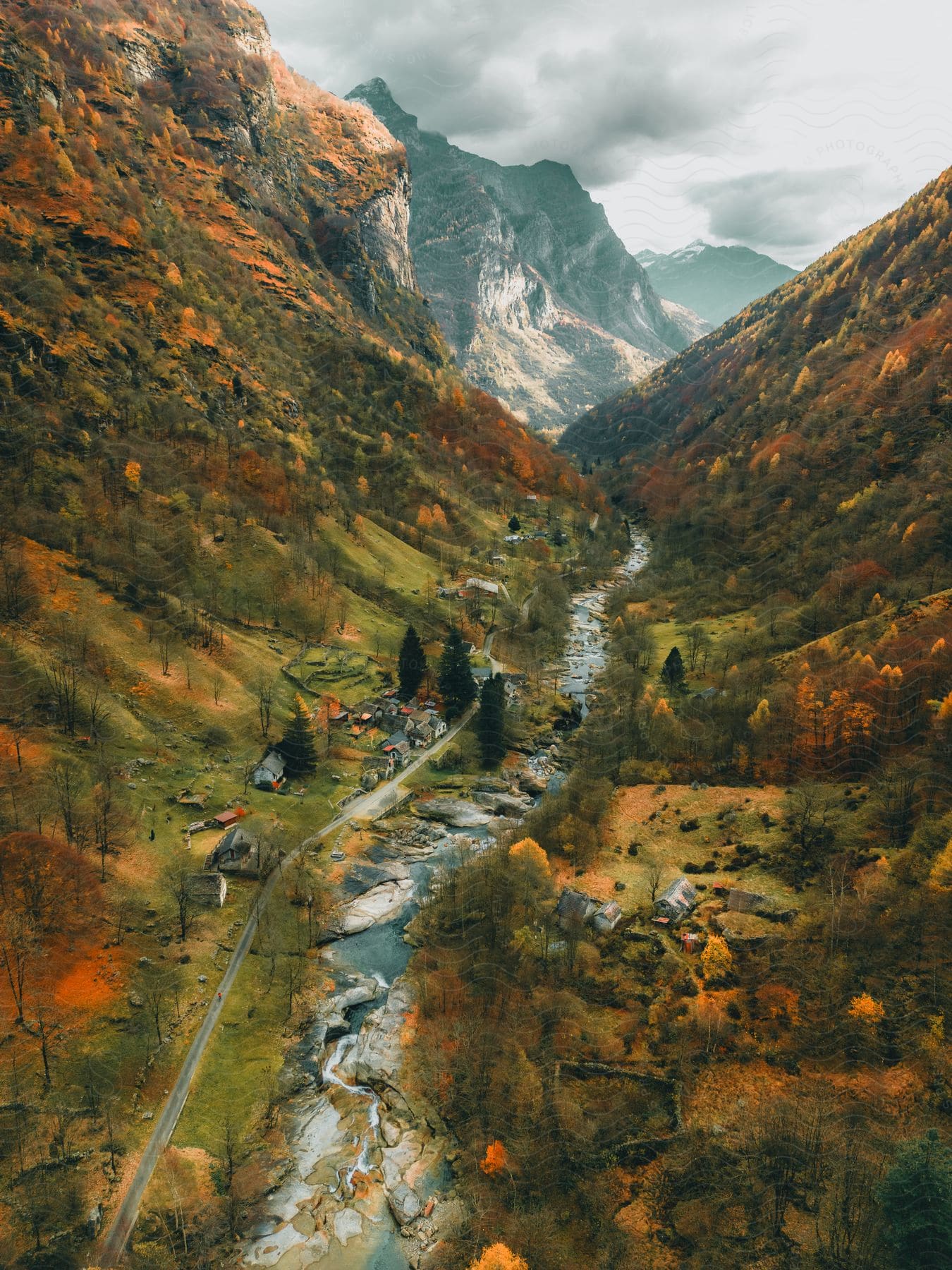 Houses on a street along a stream in a small mountain valley village