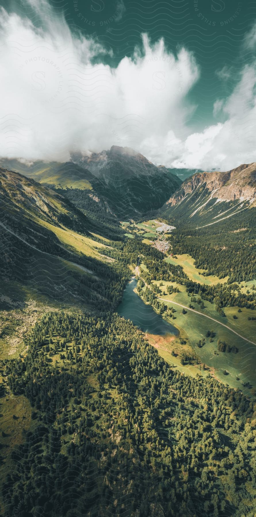 An aerial view of a town nestled near a forest in a lush green valley.