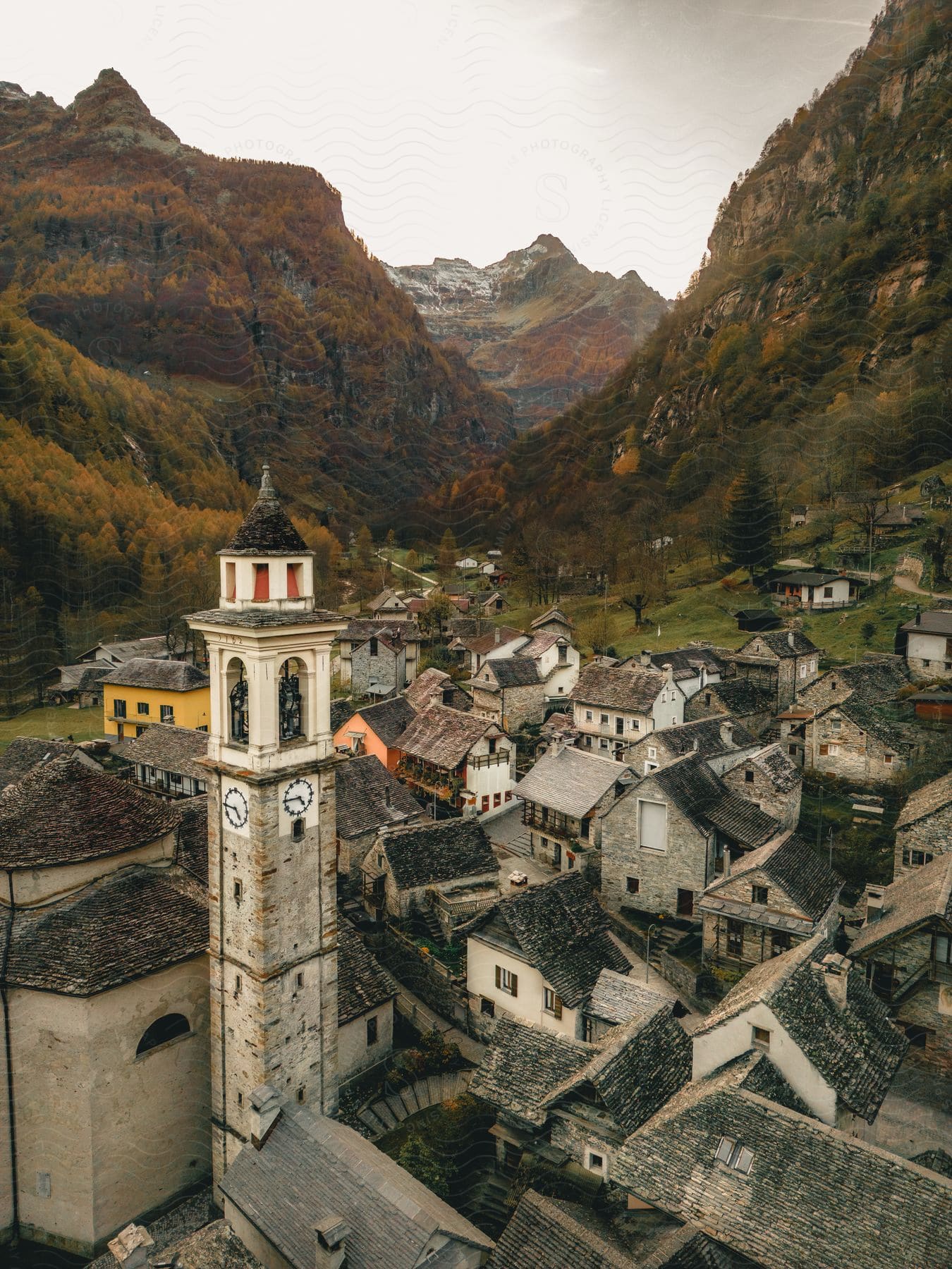 A clocktower overlooks a mountain valley village