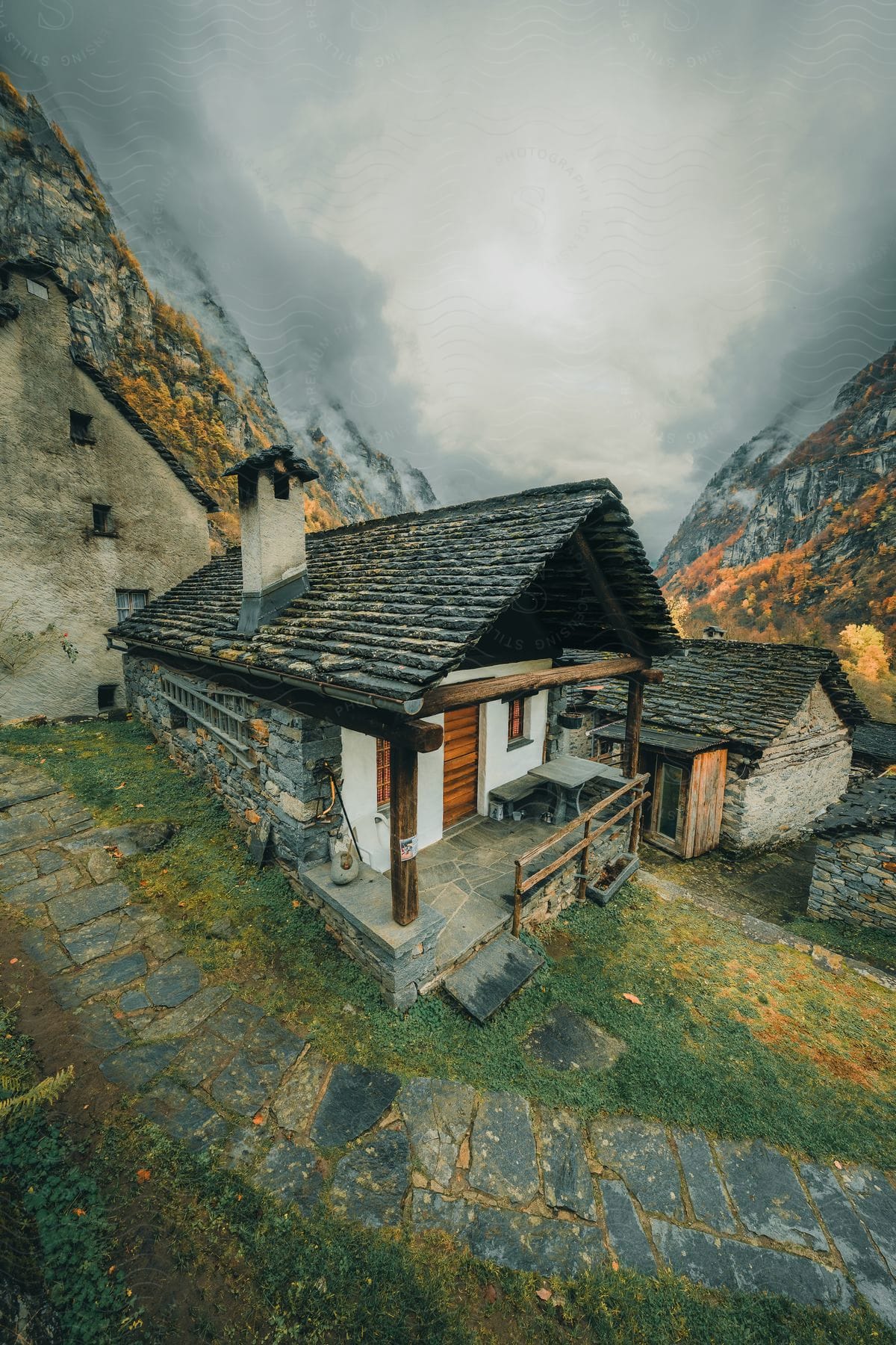 Houses at the foot of mountains under a foggy sky