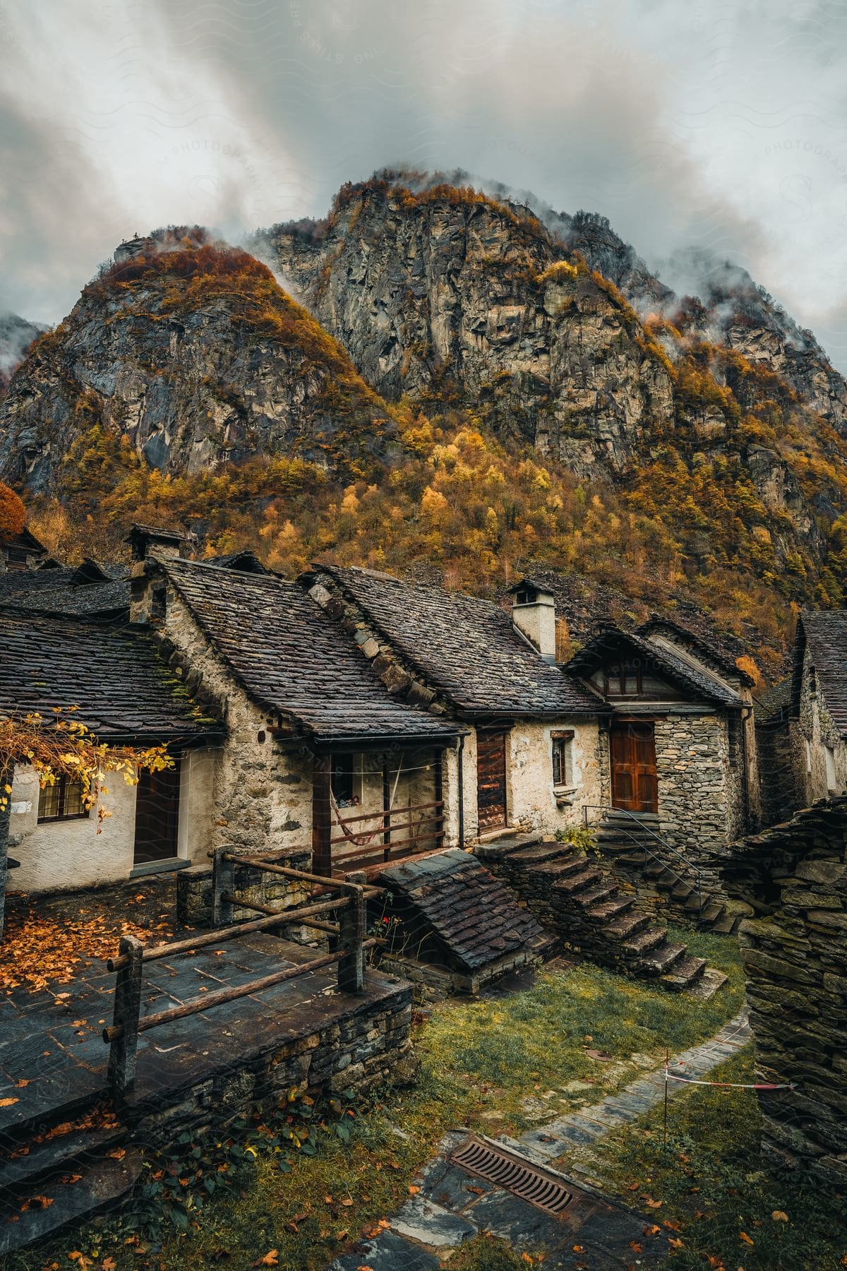 Some houses in a rural area at the base of a mountain.