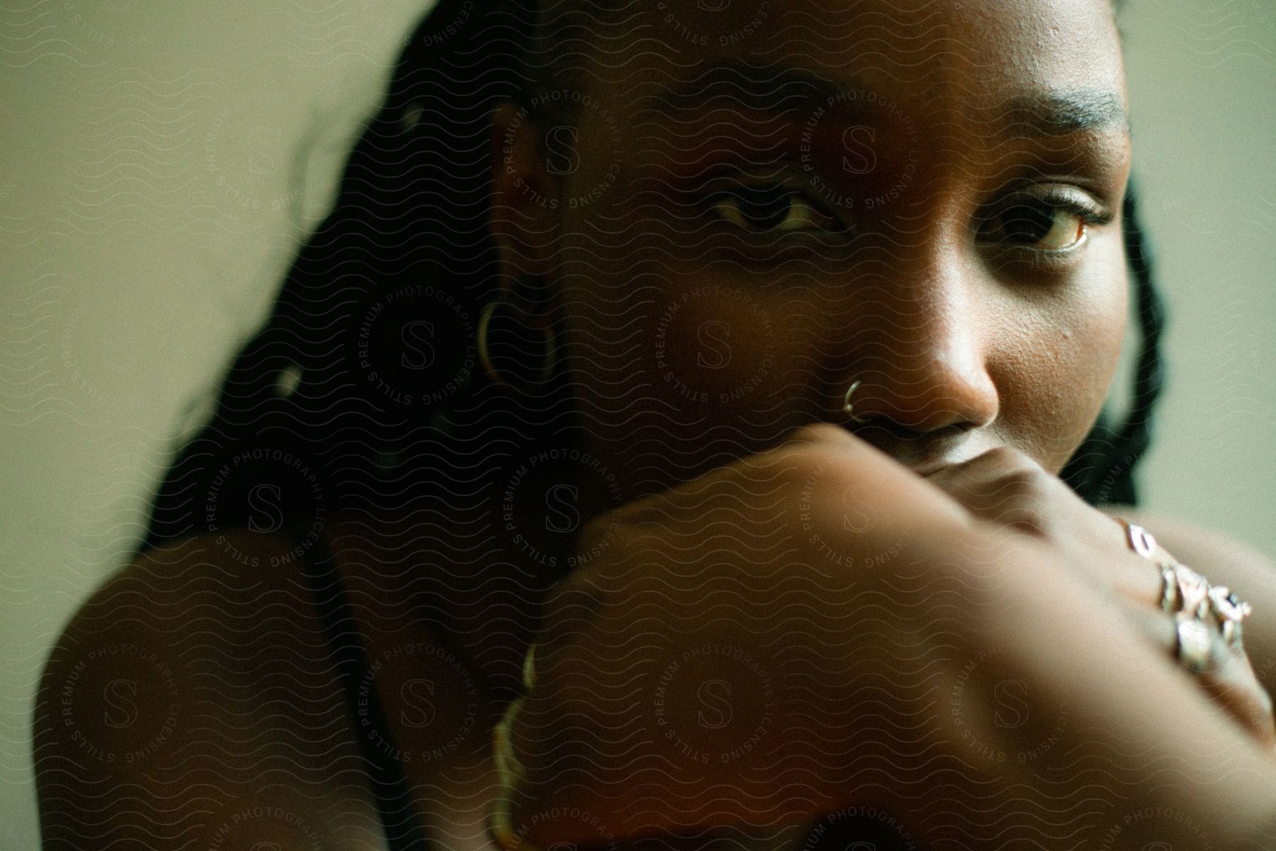 Close up of woman’s face with a nose piercing earrings and rings