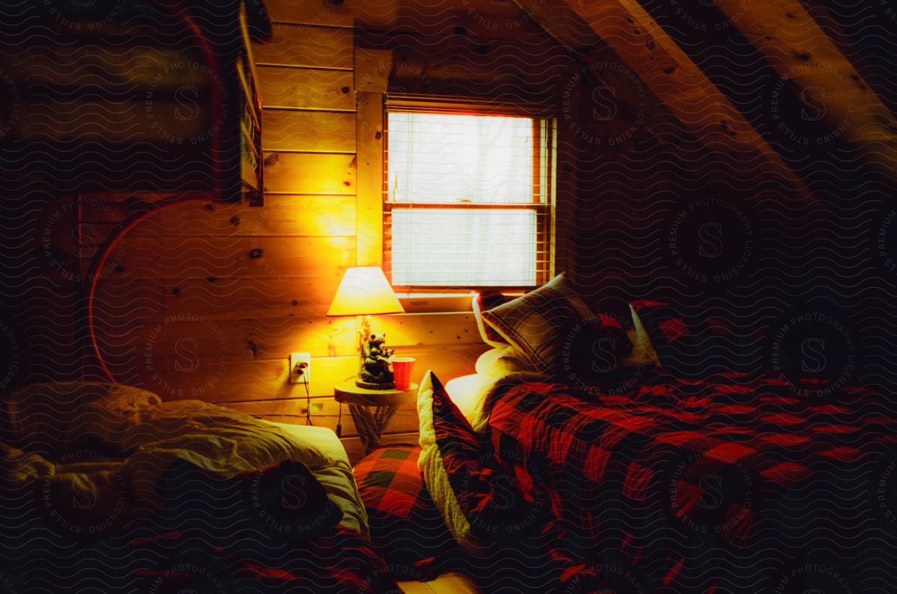 A bedroom with rustic decor lit by a lamp.