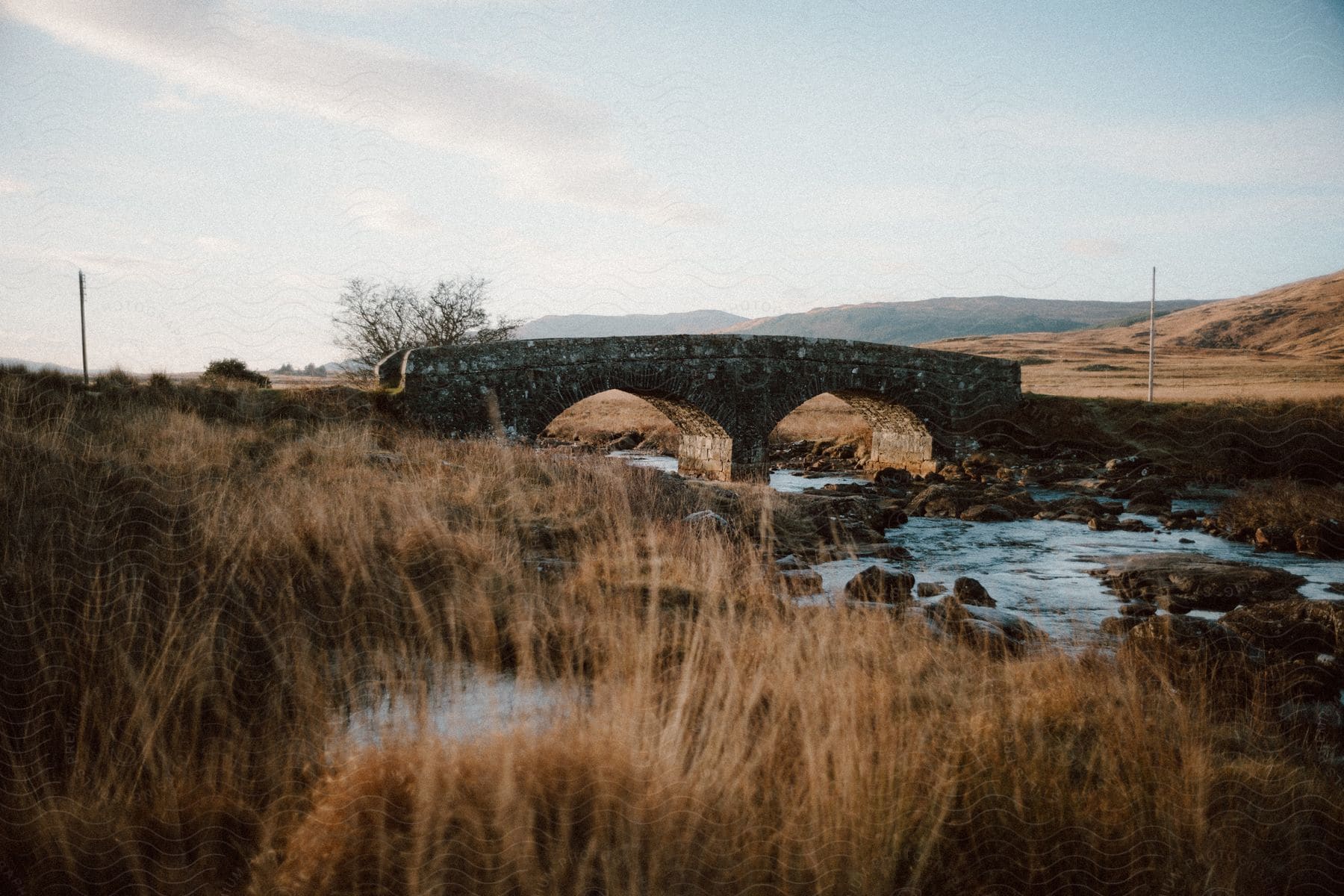 stone bridge over stream in dry brush landscape