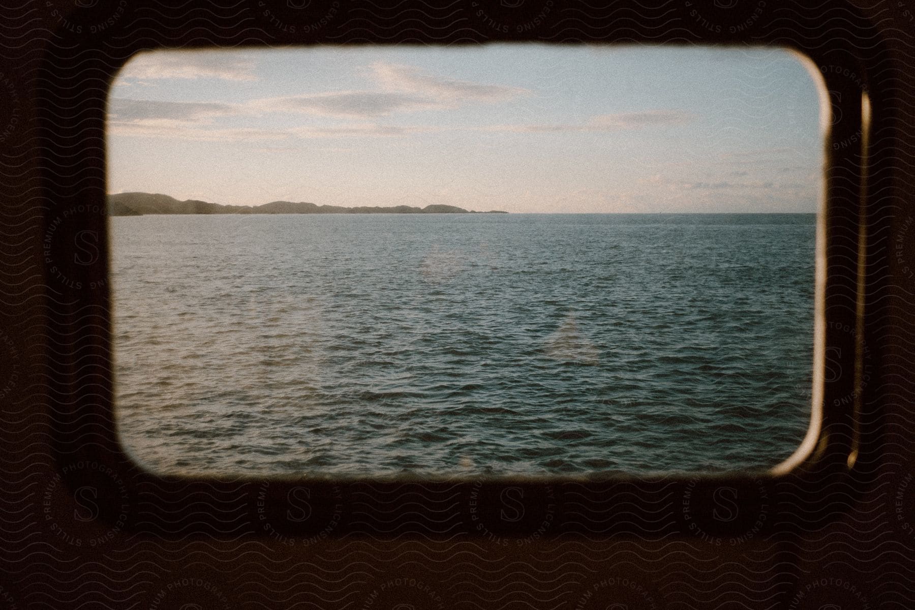 View from a ship window of the water and coastline