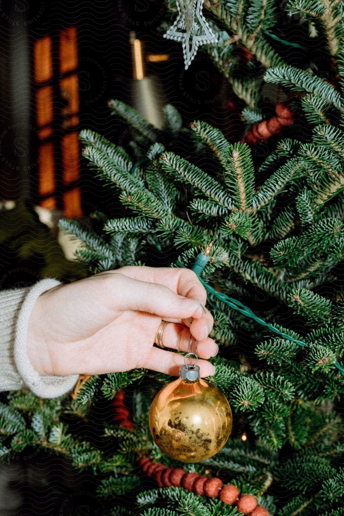 Man’s hand decorates christmas tree