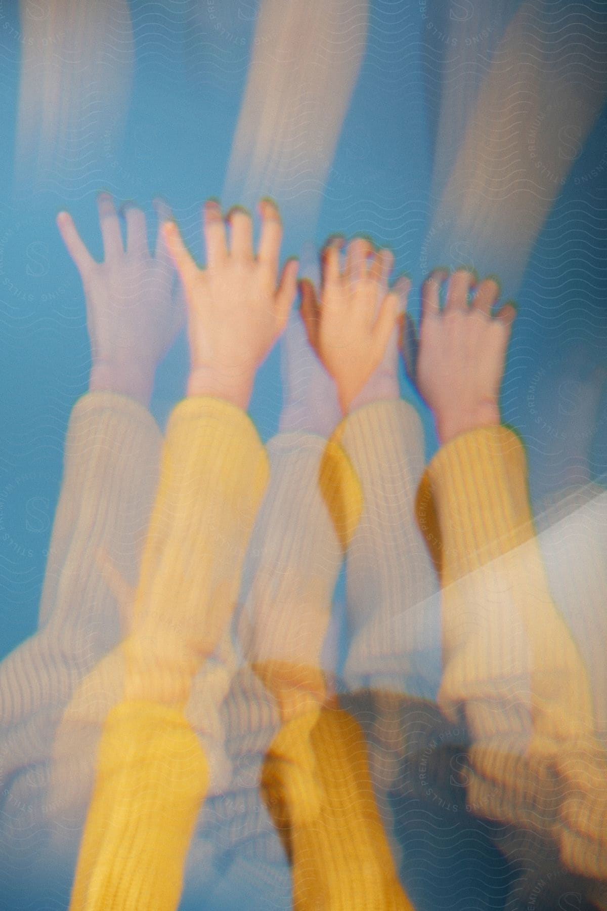 Multiple exposures of a person's arm highlights the bright colors of their sweater sleeve.