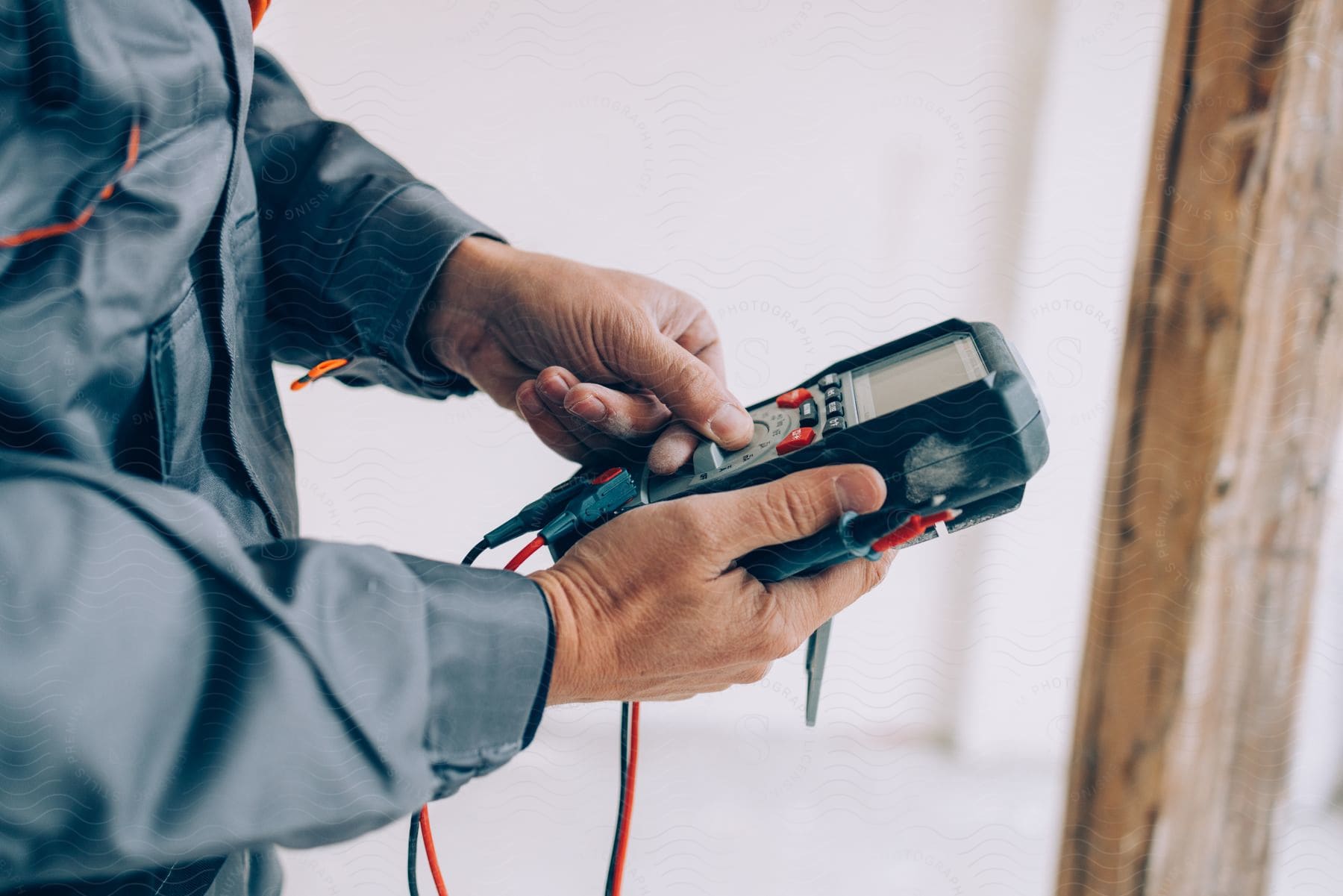 A man using an electrical meter in a room