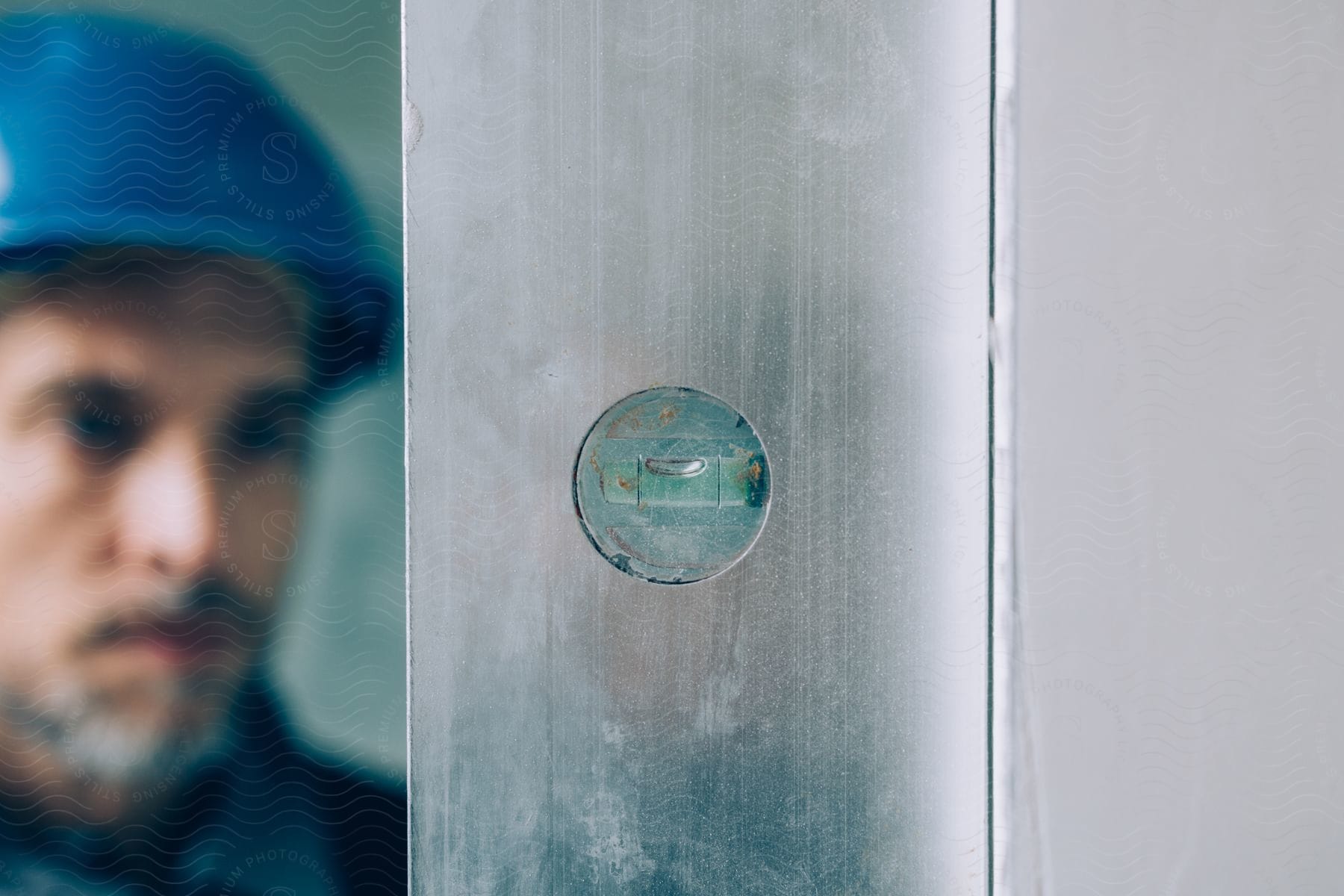 A level bubble in a panel with a hardhat construction worker behind