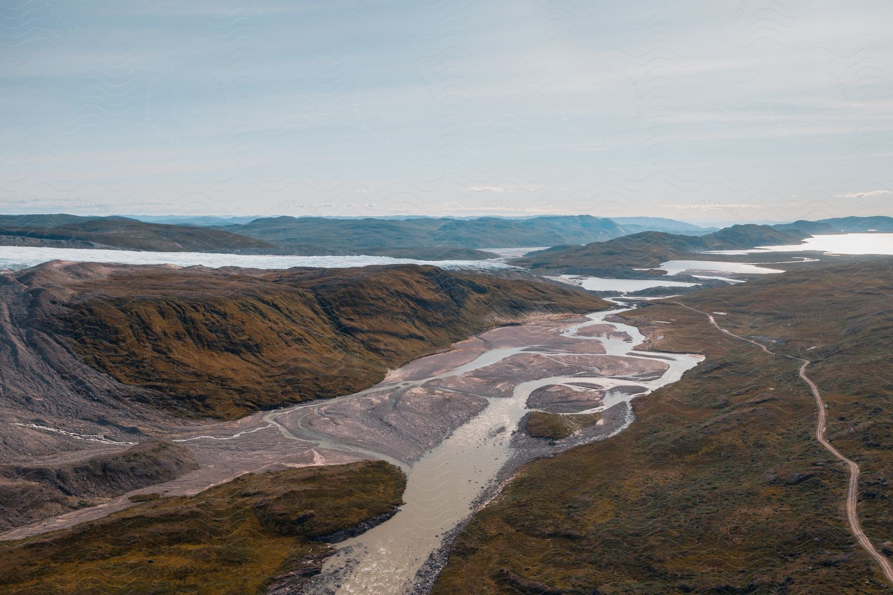 Aerial of a stream between mountains during the day.