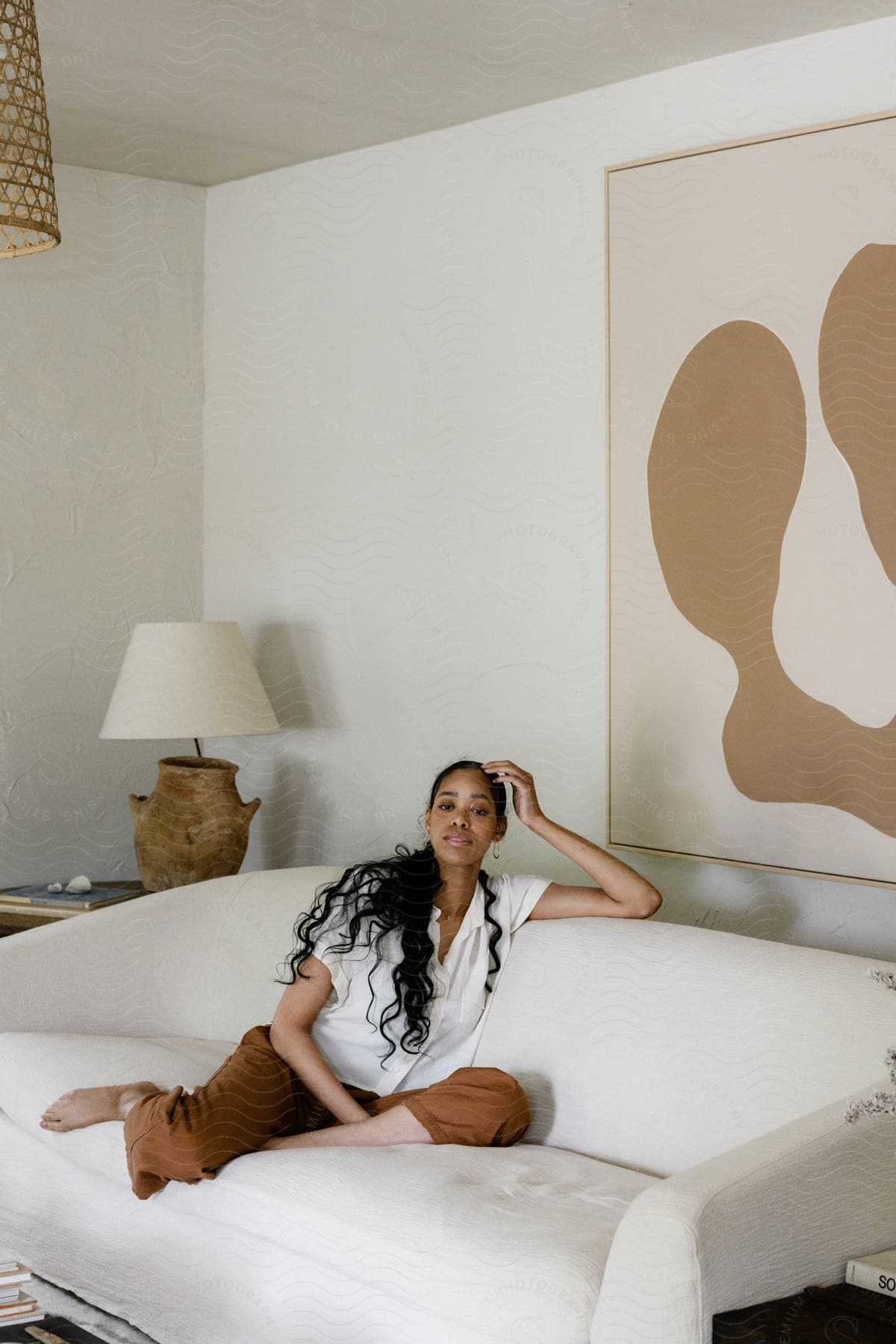 Model woman sitting on a white retro couch.