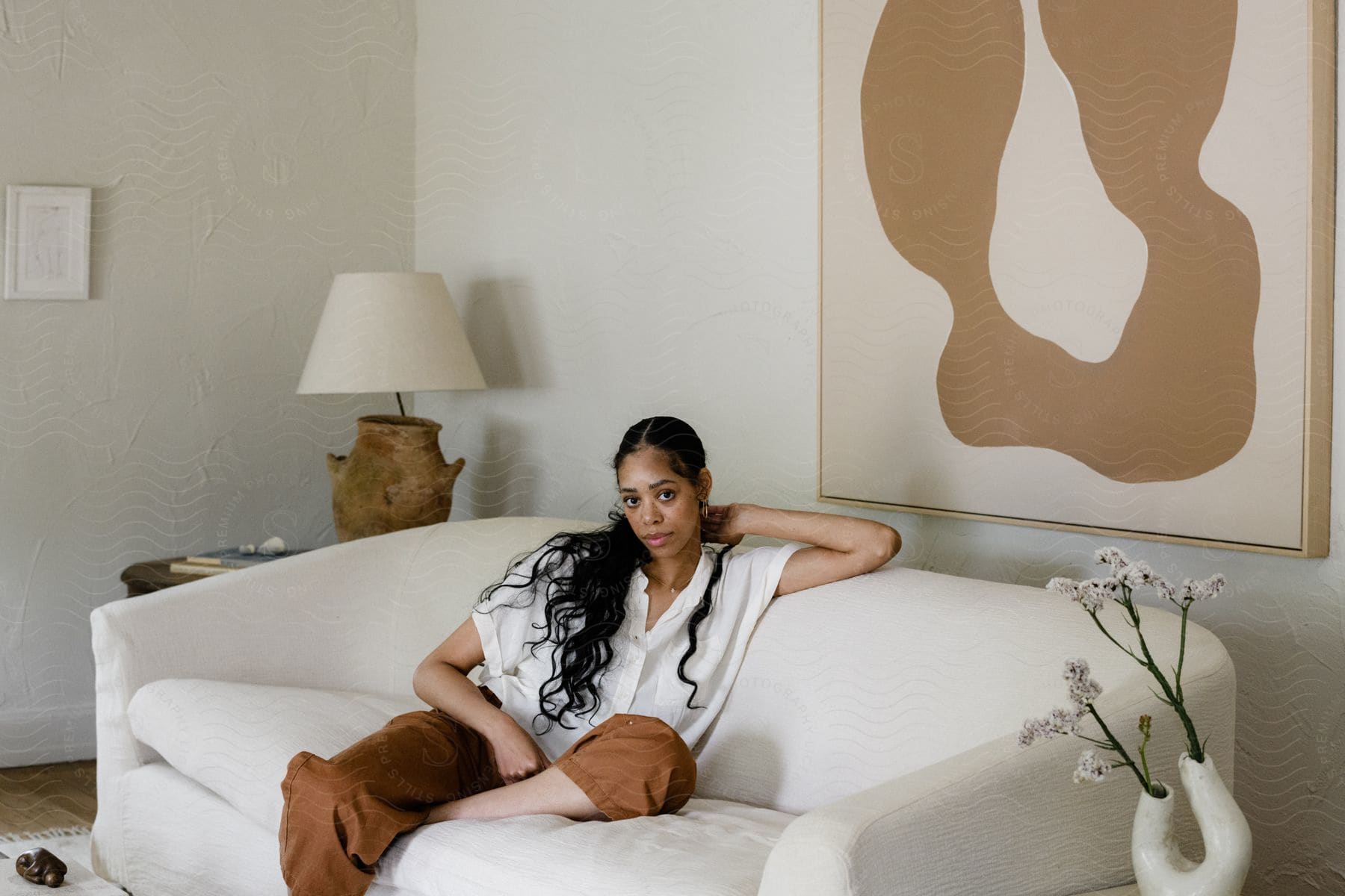 A woman sitting on a couch modeling clothes.