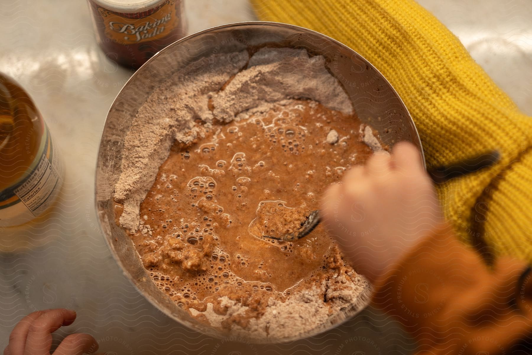 A person mixing ingredients in a bowl.