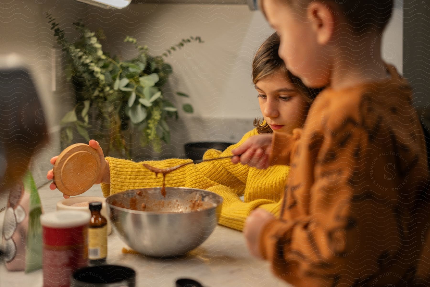 Two children cooking food in a kitchen together.