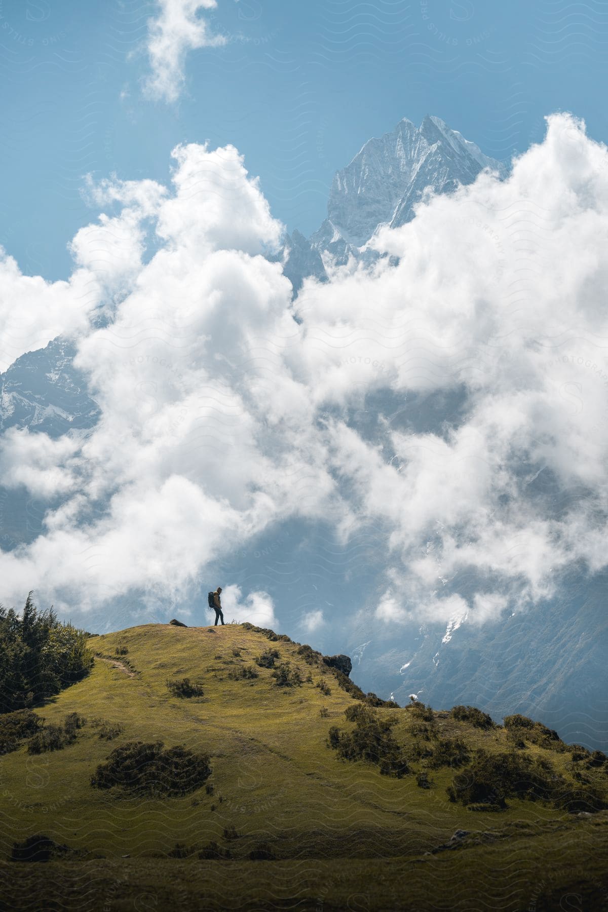 A man hiking on the top of a mountain during a sunny day.