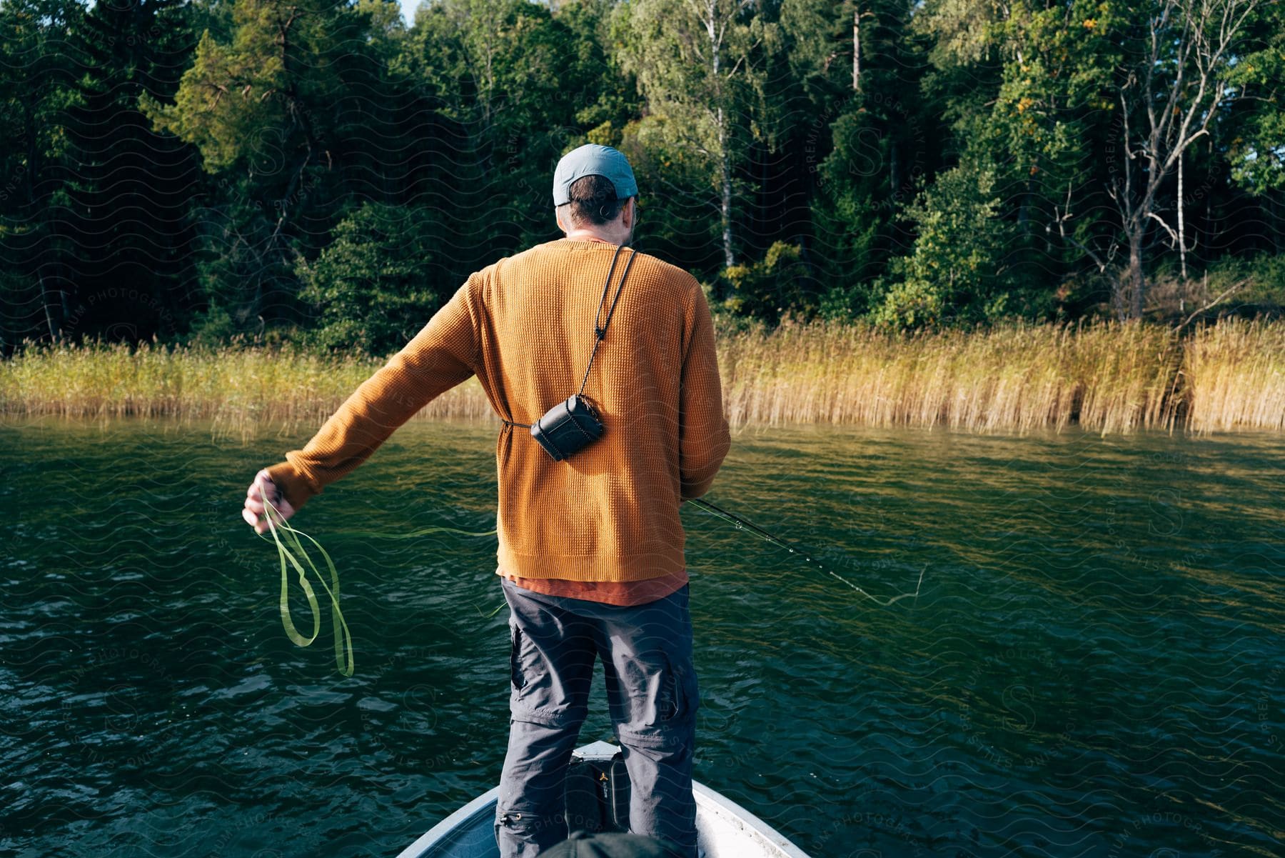 Man Standing In A Small Boat Fishing On A Lake