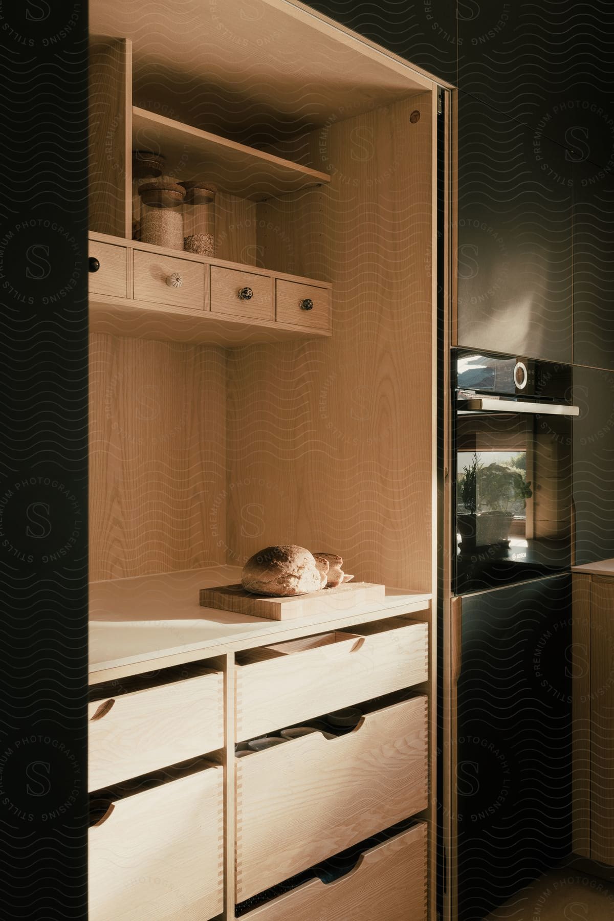 Simple kitchen with oven, storage drawers, and bread on counter.