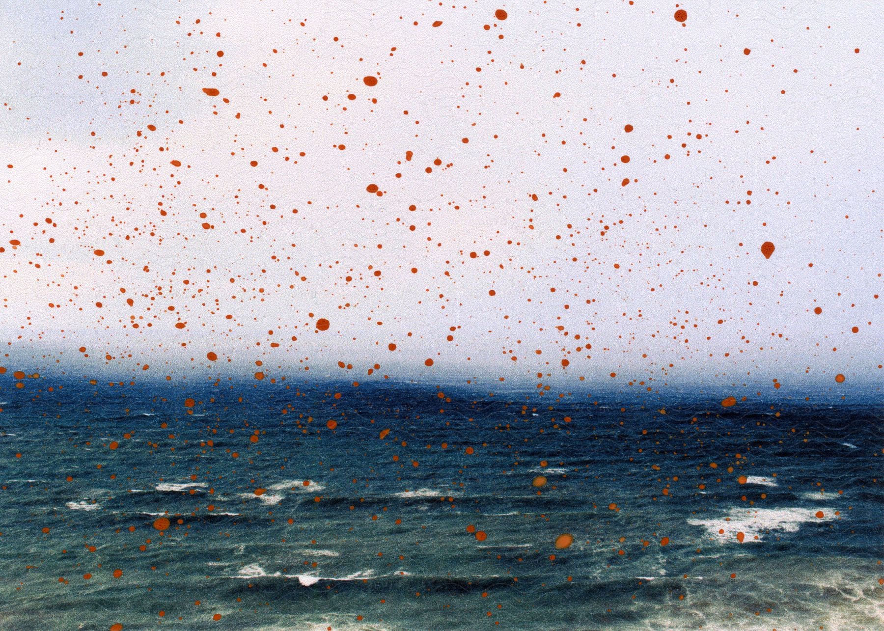 Brown droplets and spots on the glass with ocean waves the horizon and clouds behind