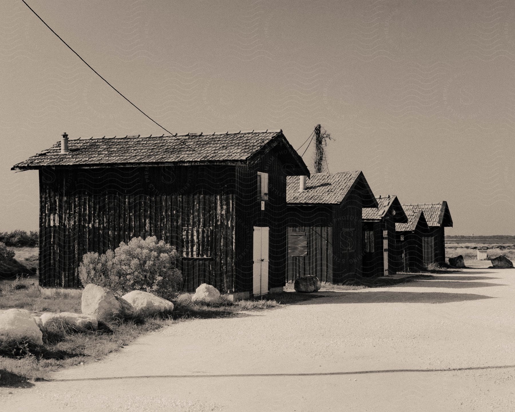 Some wooden houses in a rural region and a light cable connecting to the houses