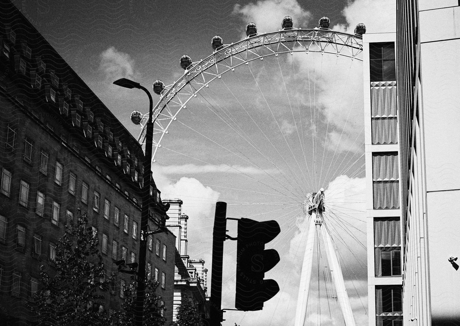 A Ferris wheel at the end of a downtown street stands above the buildings