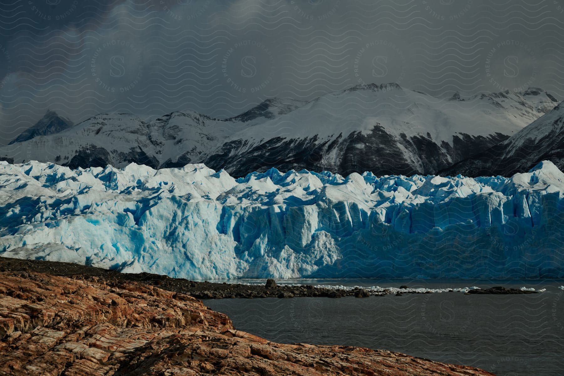 The Perito Moreno Glacier in Argentina with snow capped mountains behind