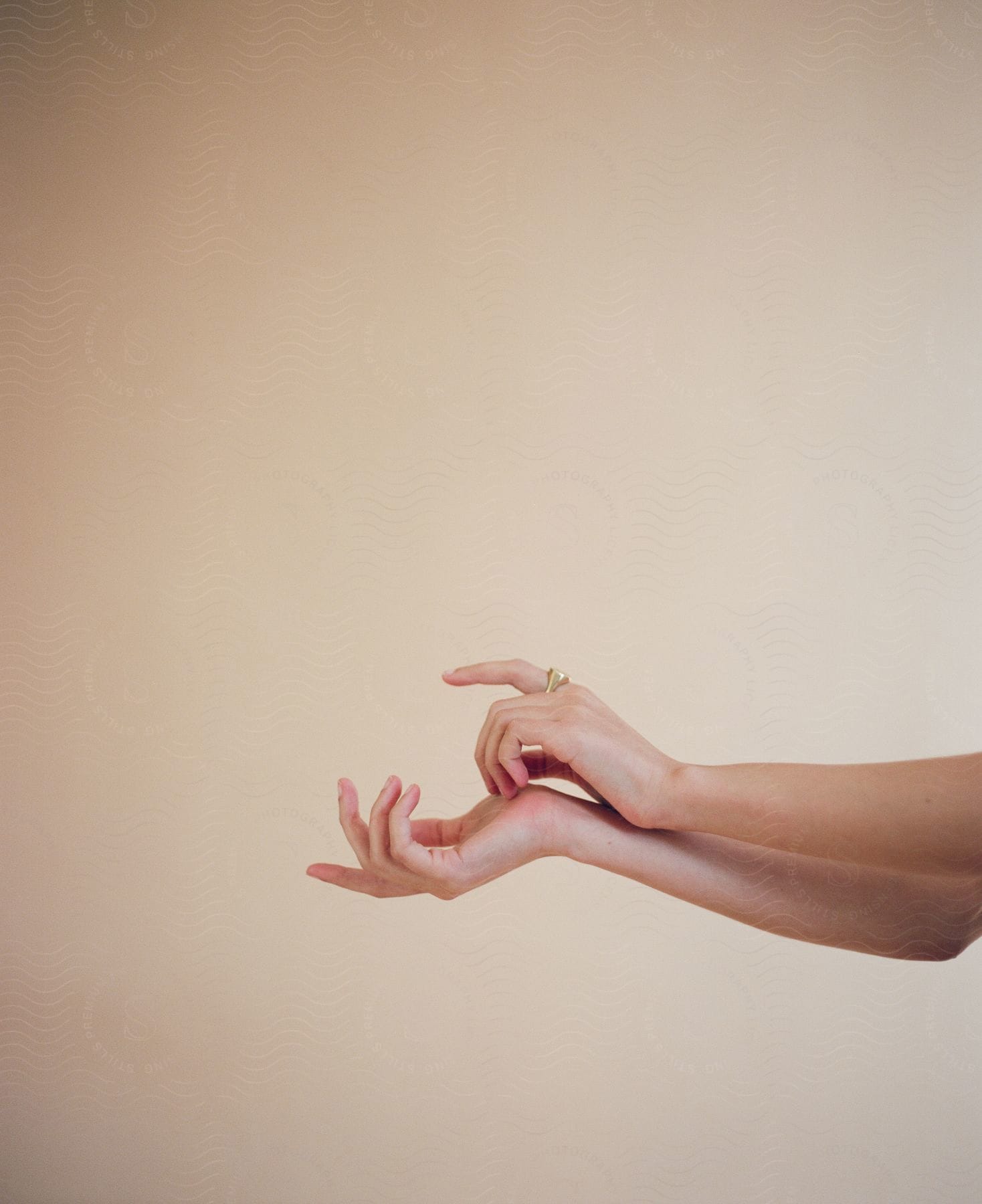 A woman poses with her arms out and hands together as she makes a gesture with her fingers
