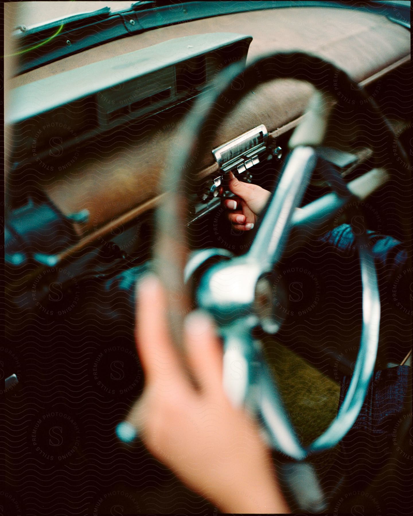 A person holding a steering wheel in a car.