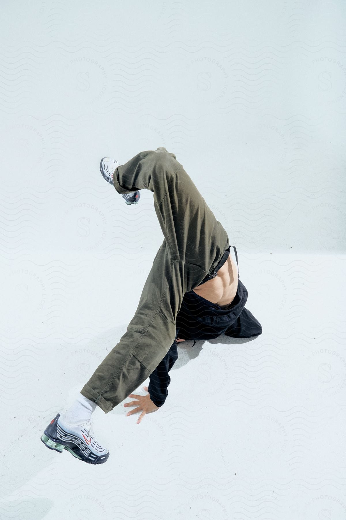 Stock photo of a break dancer doing a handstand against a white background.