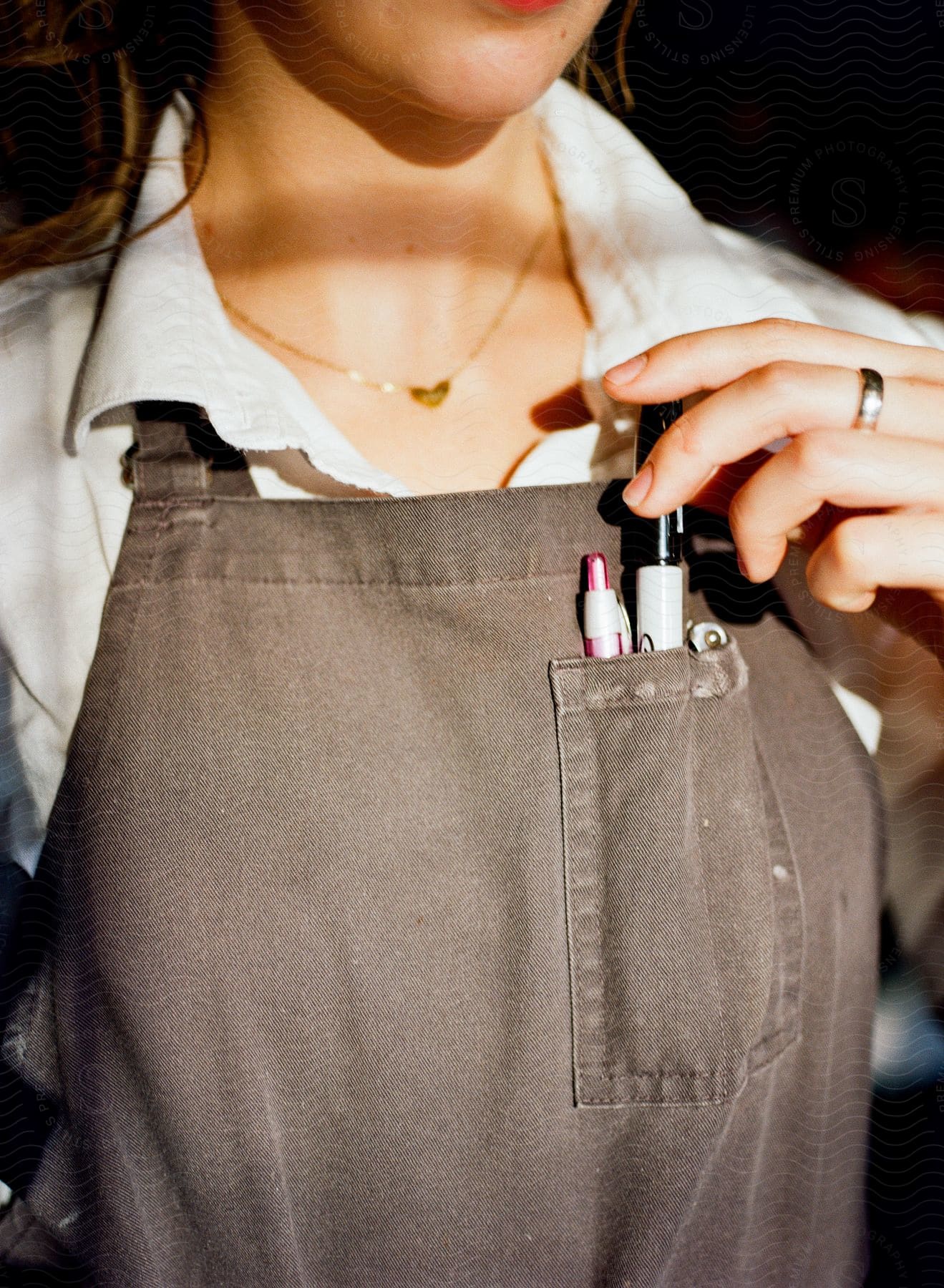 a lady holding a pen in her front pocket