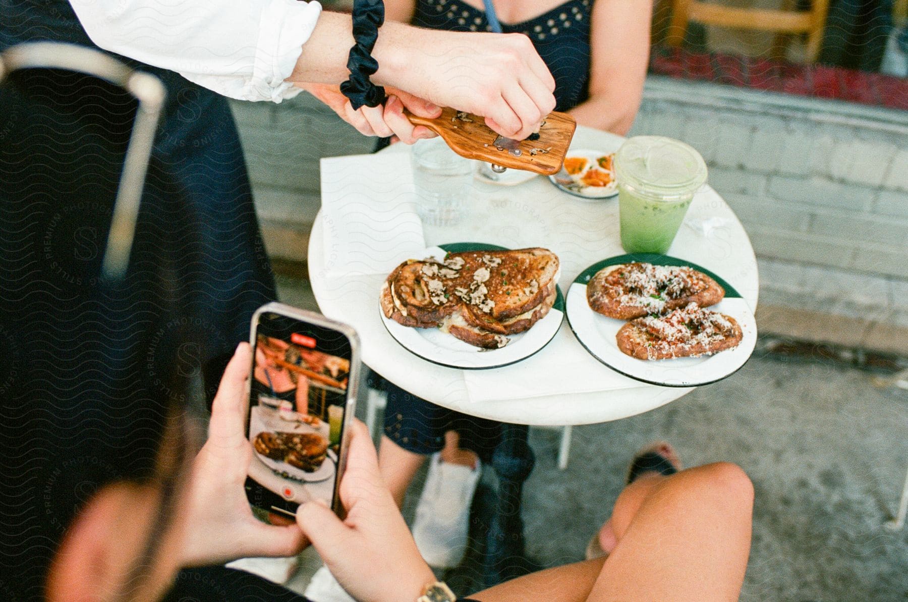 Two people being served food outdoors at a cafe.