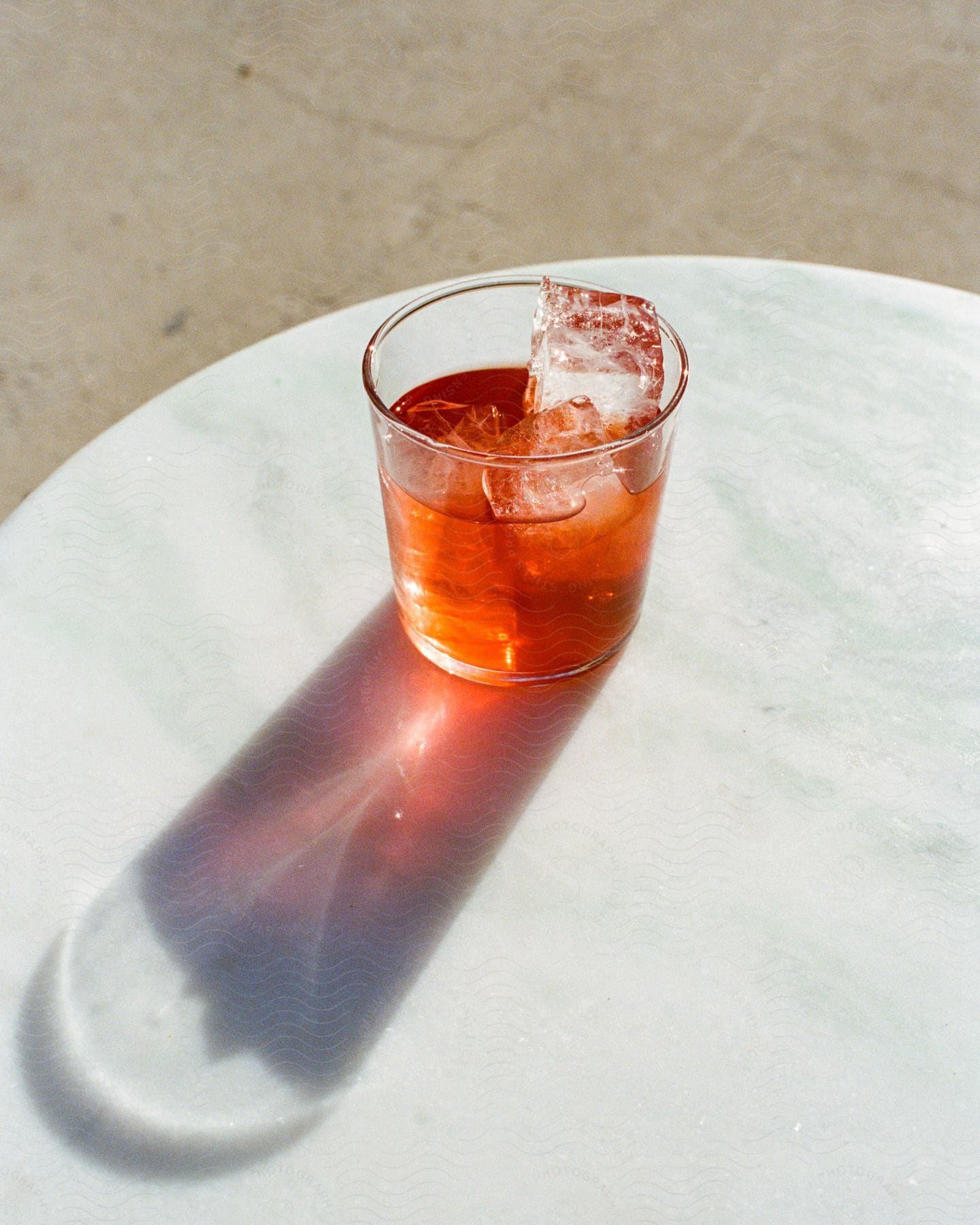An iced beverage sits on top of a small outdoor dining table.