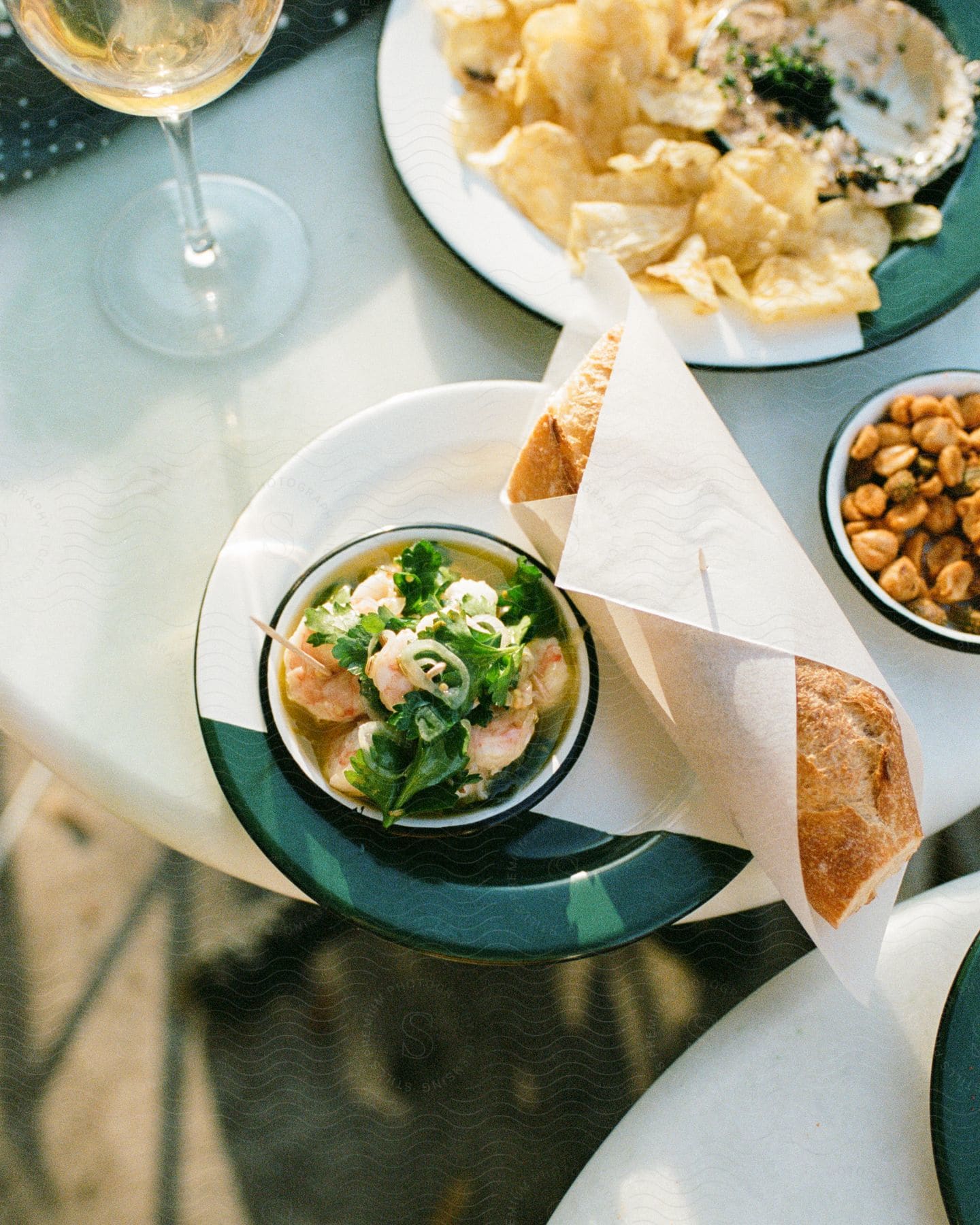 Meals on a table with wrapped bread and a glass of wine