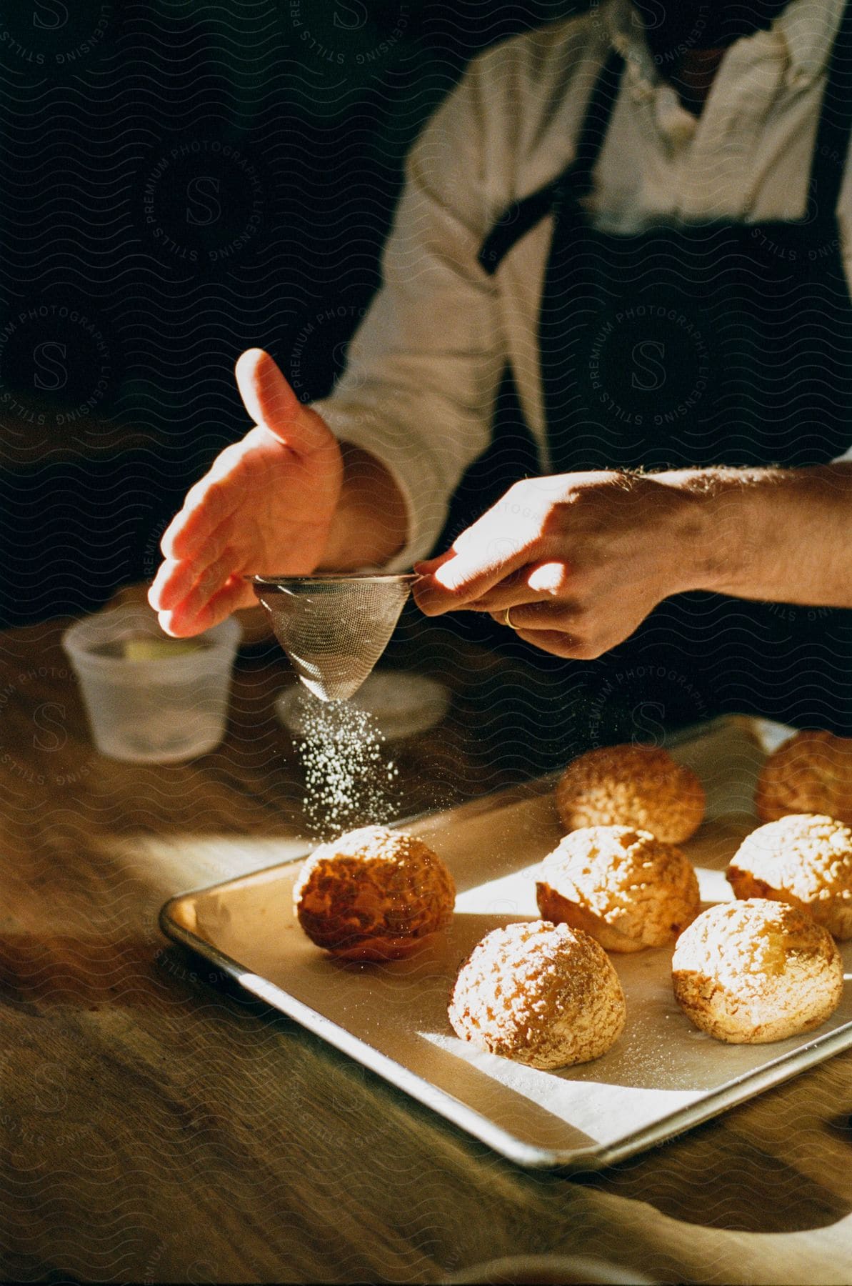 A person putting sugar on some food they are cooking.