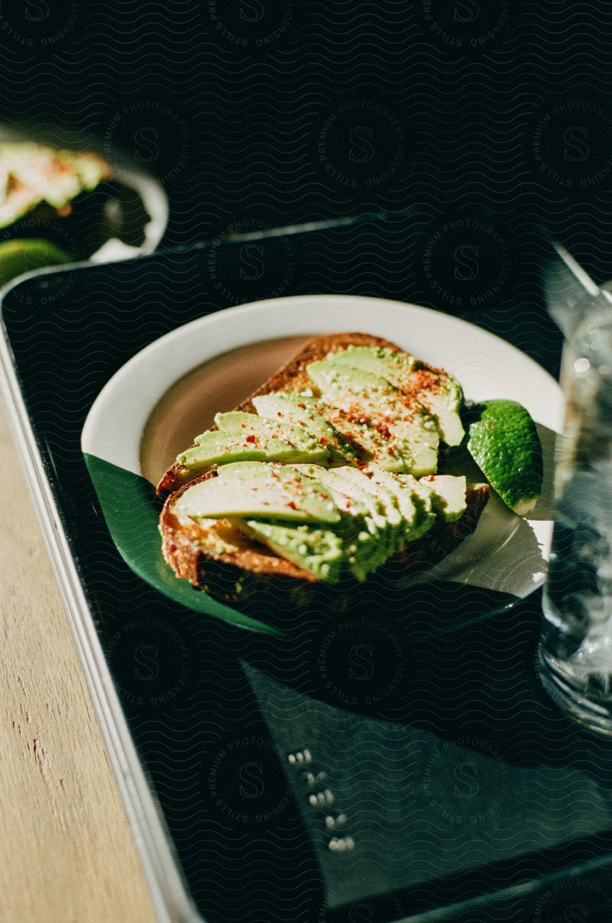 Avocado toast and a glass of ice water on a tray