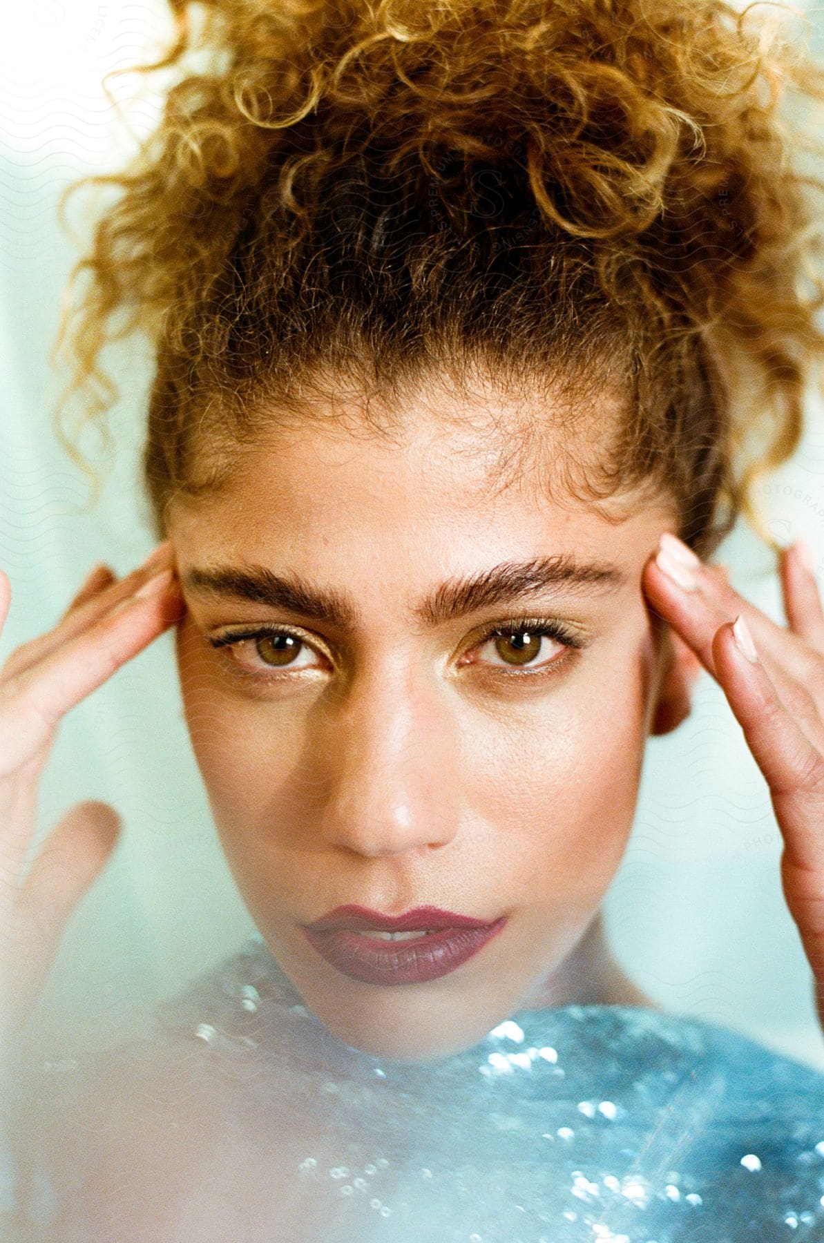 A portrait of a beautiful young woman with curly hair.