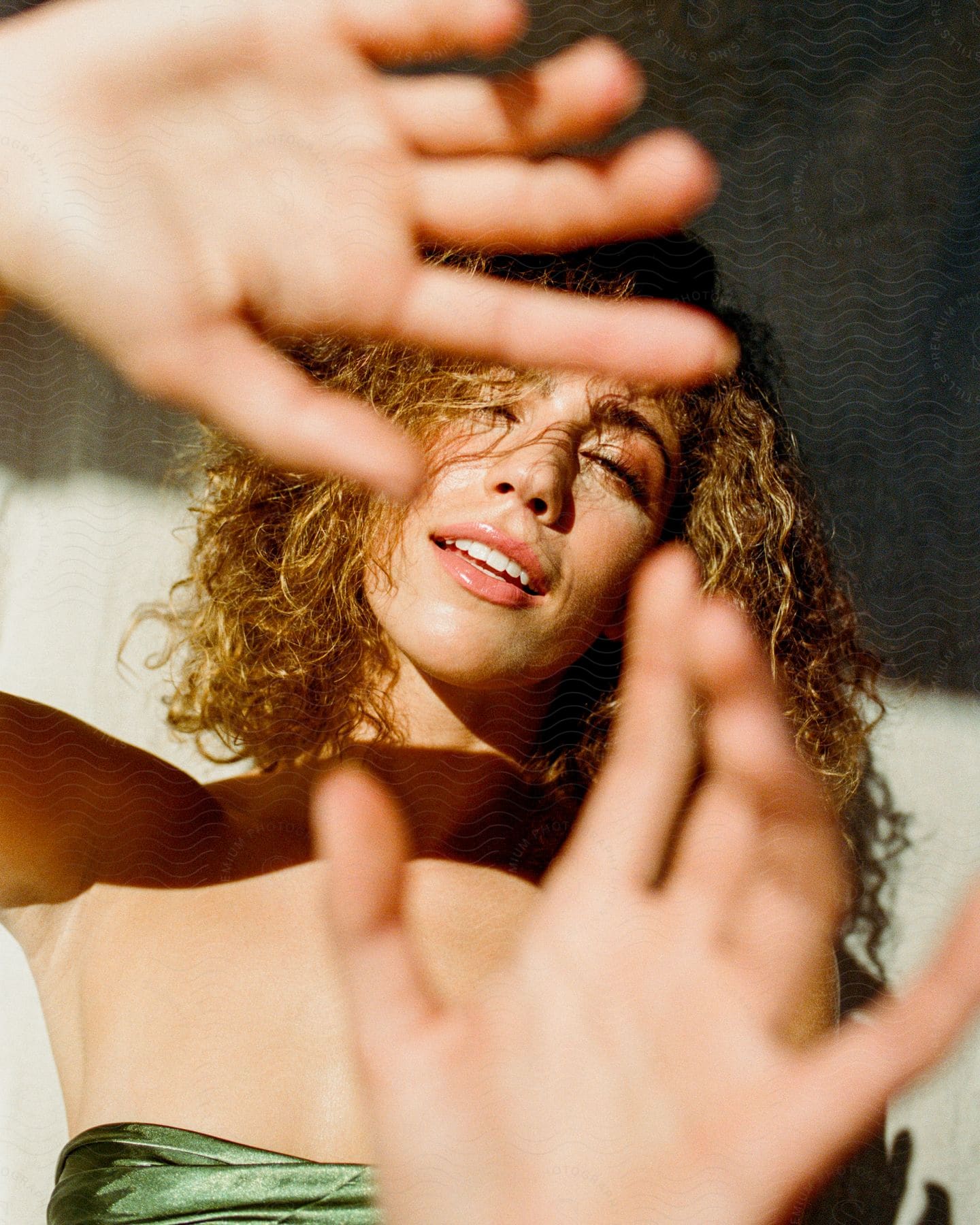 Close-up of a young woman's face with her hands extended forward.