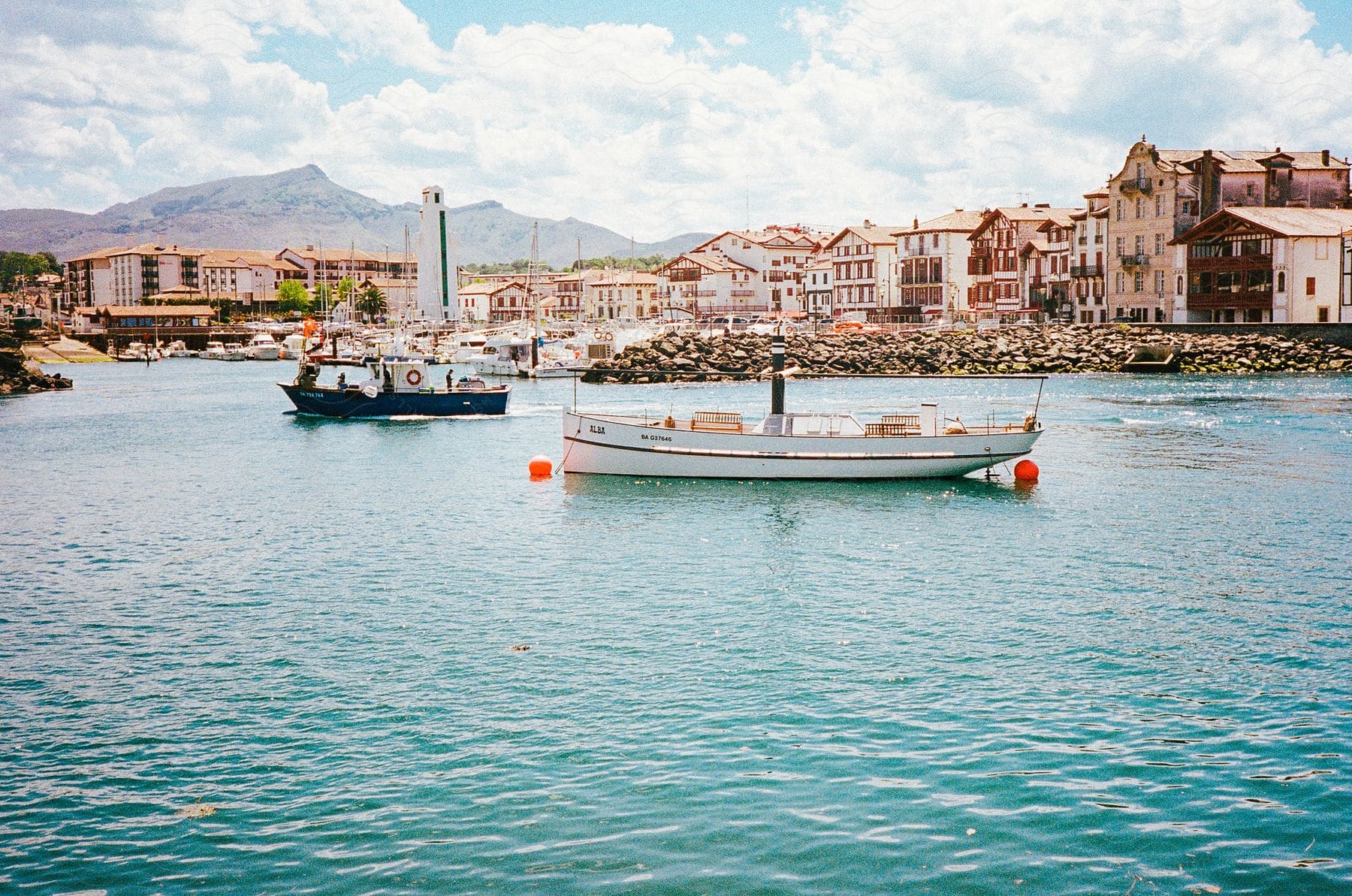 a city close to the river bank with boats seen on the river