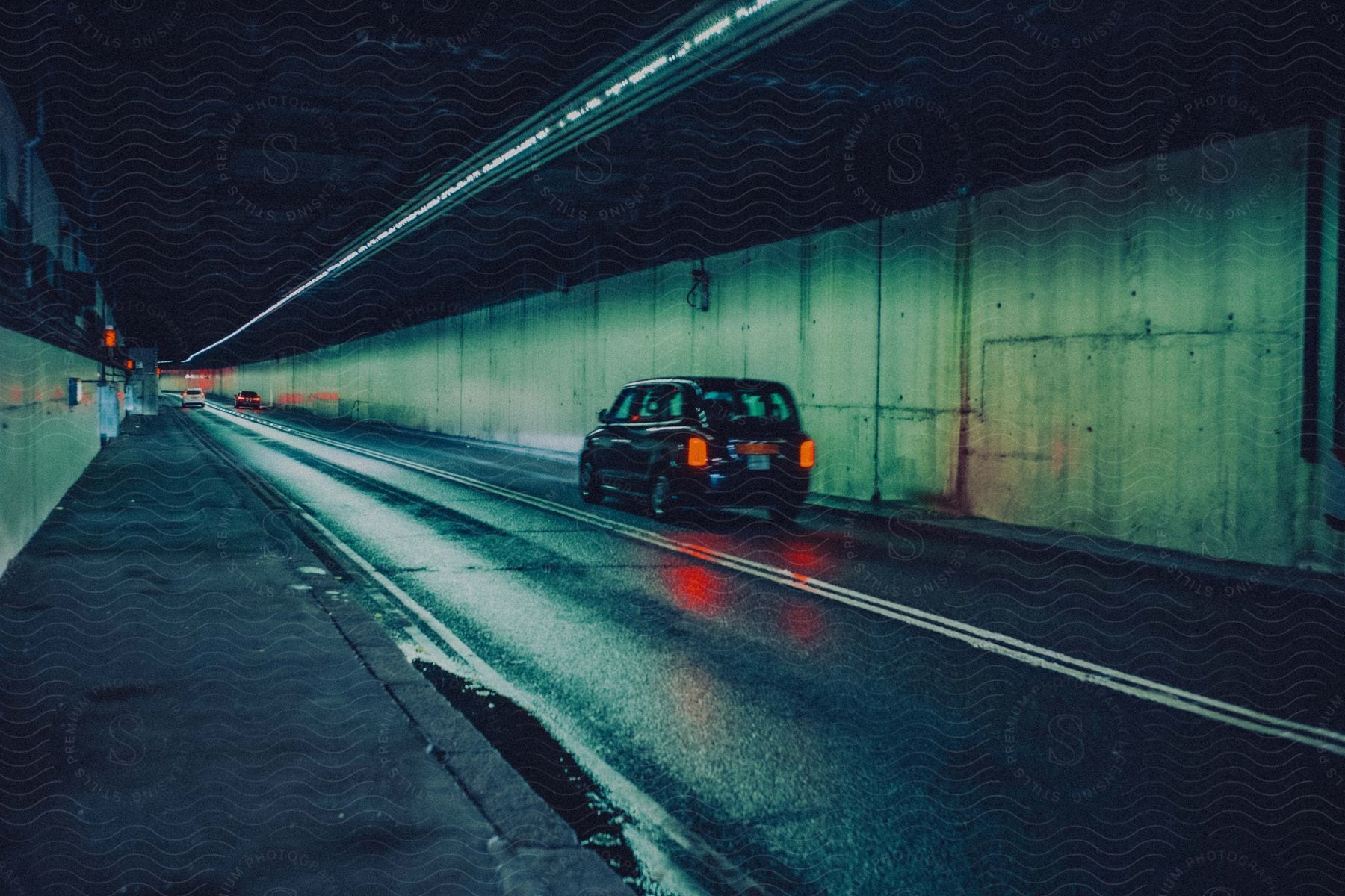 a car driving under a tunnel at night