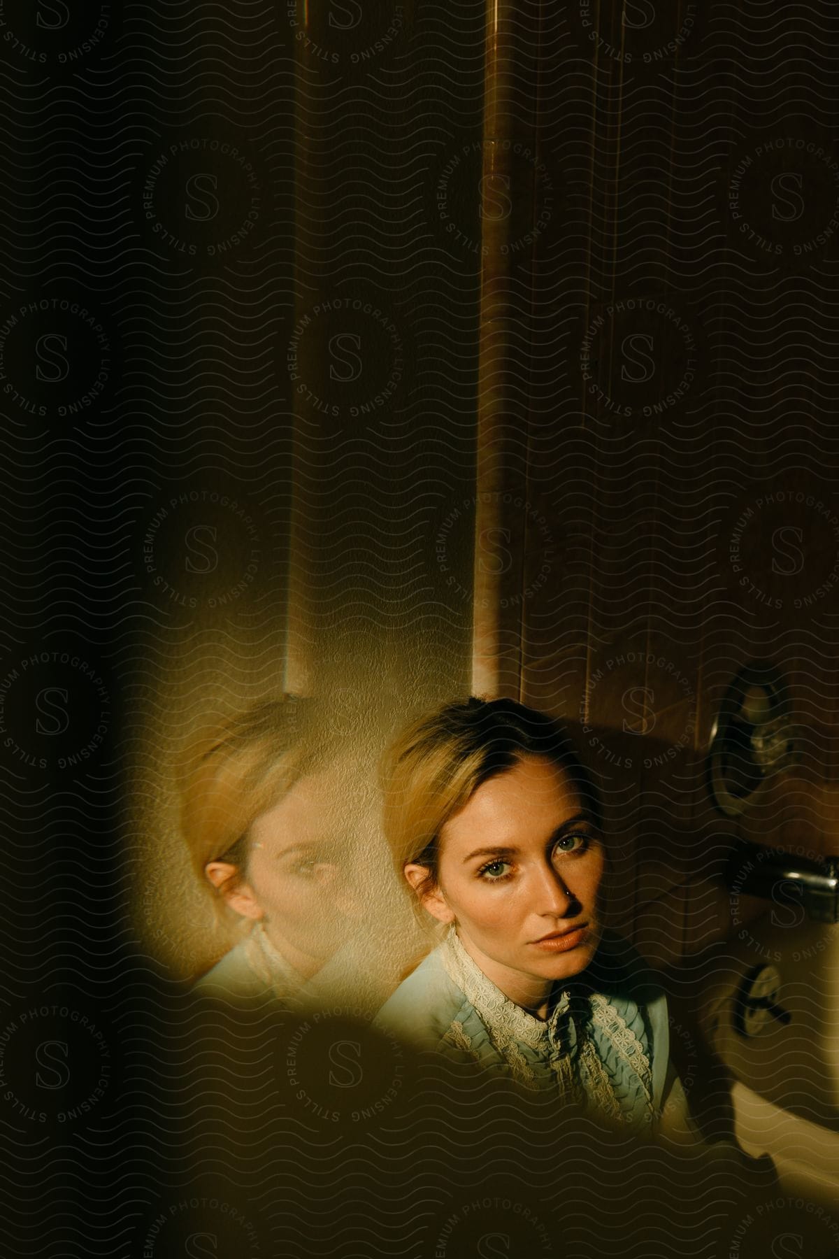 A woman is sitting near a bathtub as she looks ahead