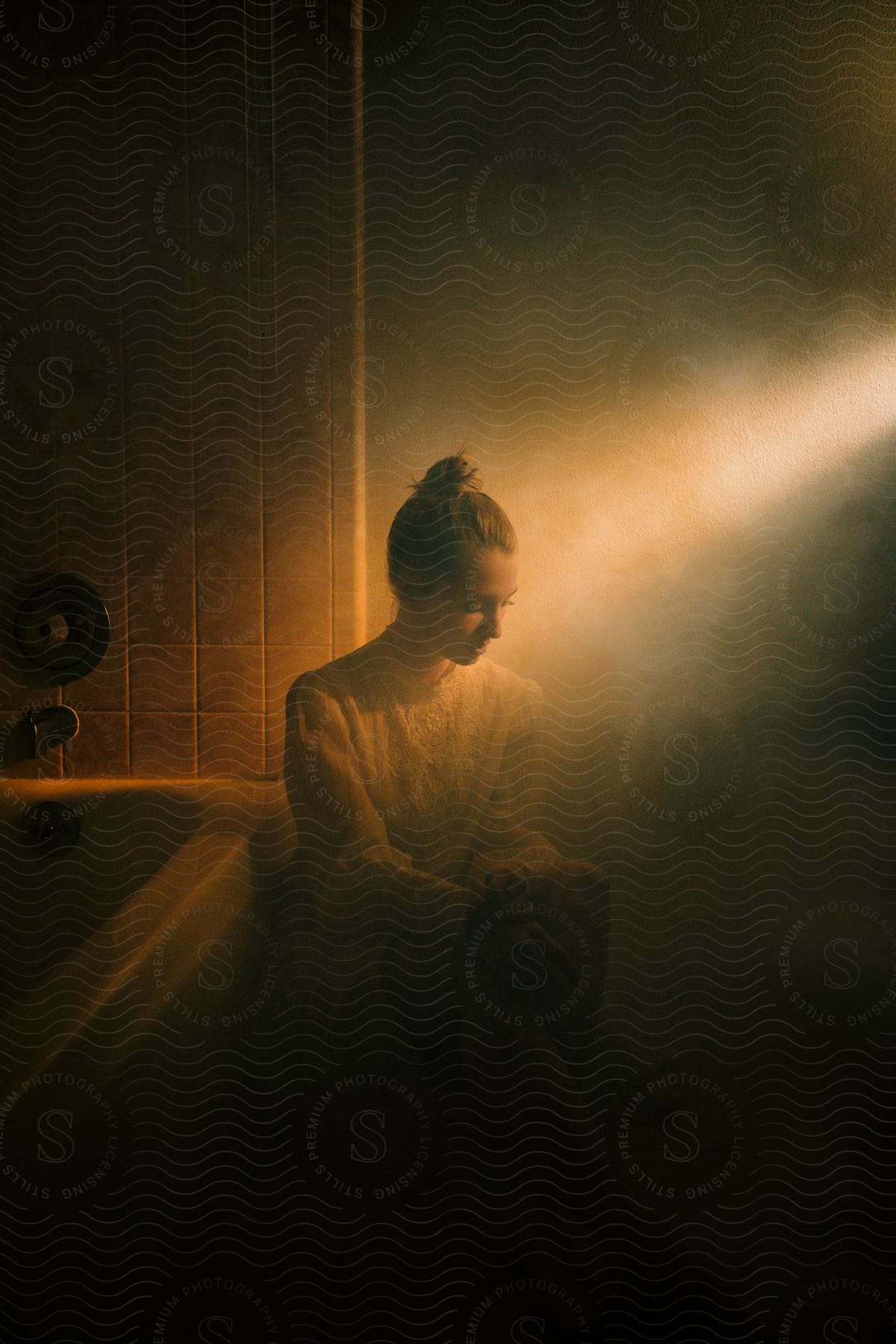 A woman sitting in the foggy bathroom.