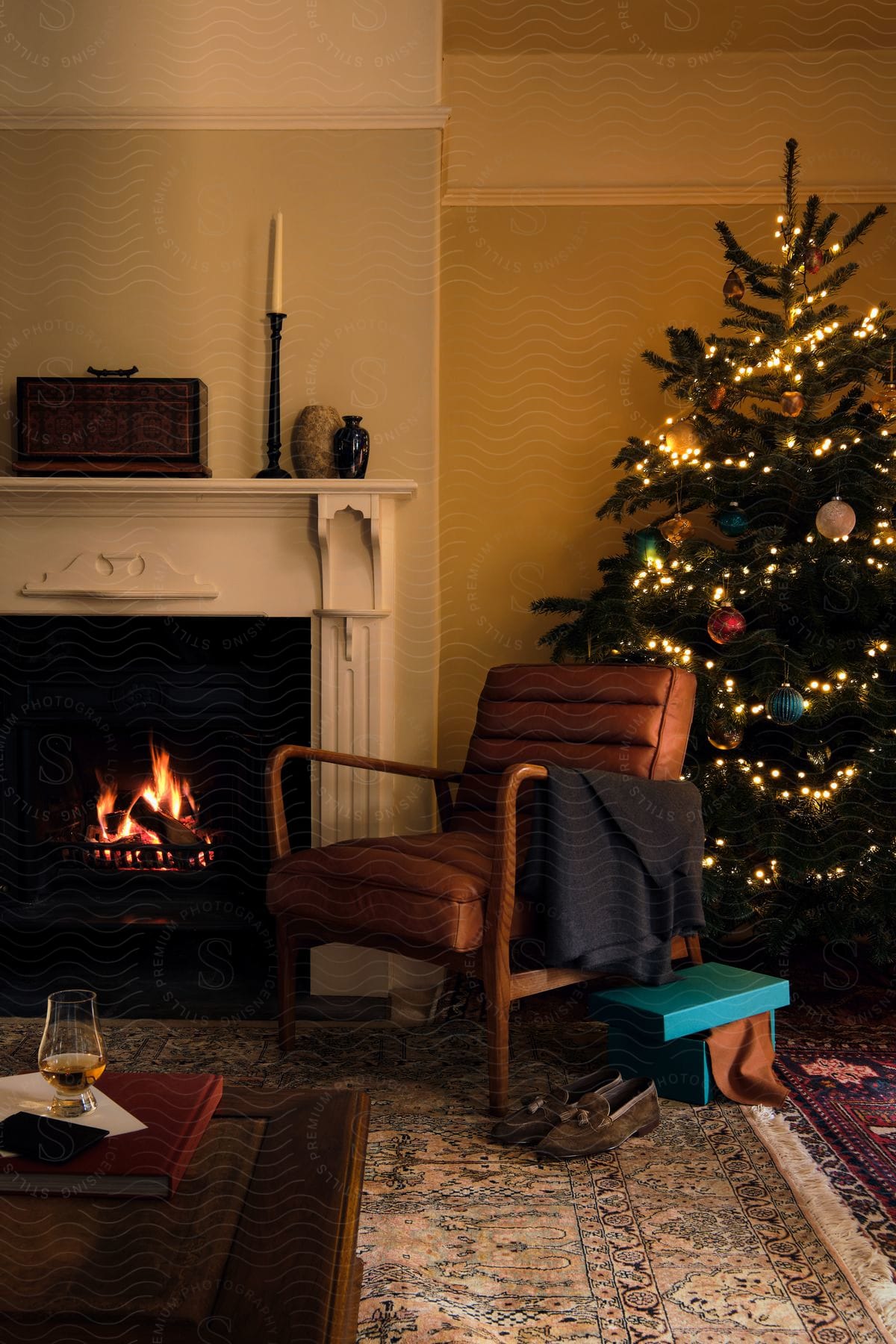 Interior design of a room with a lit fireplace next to a Christmas tree.