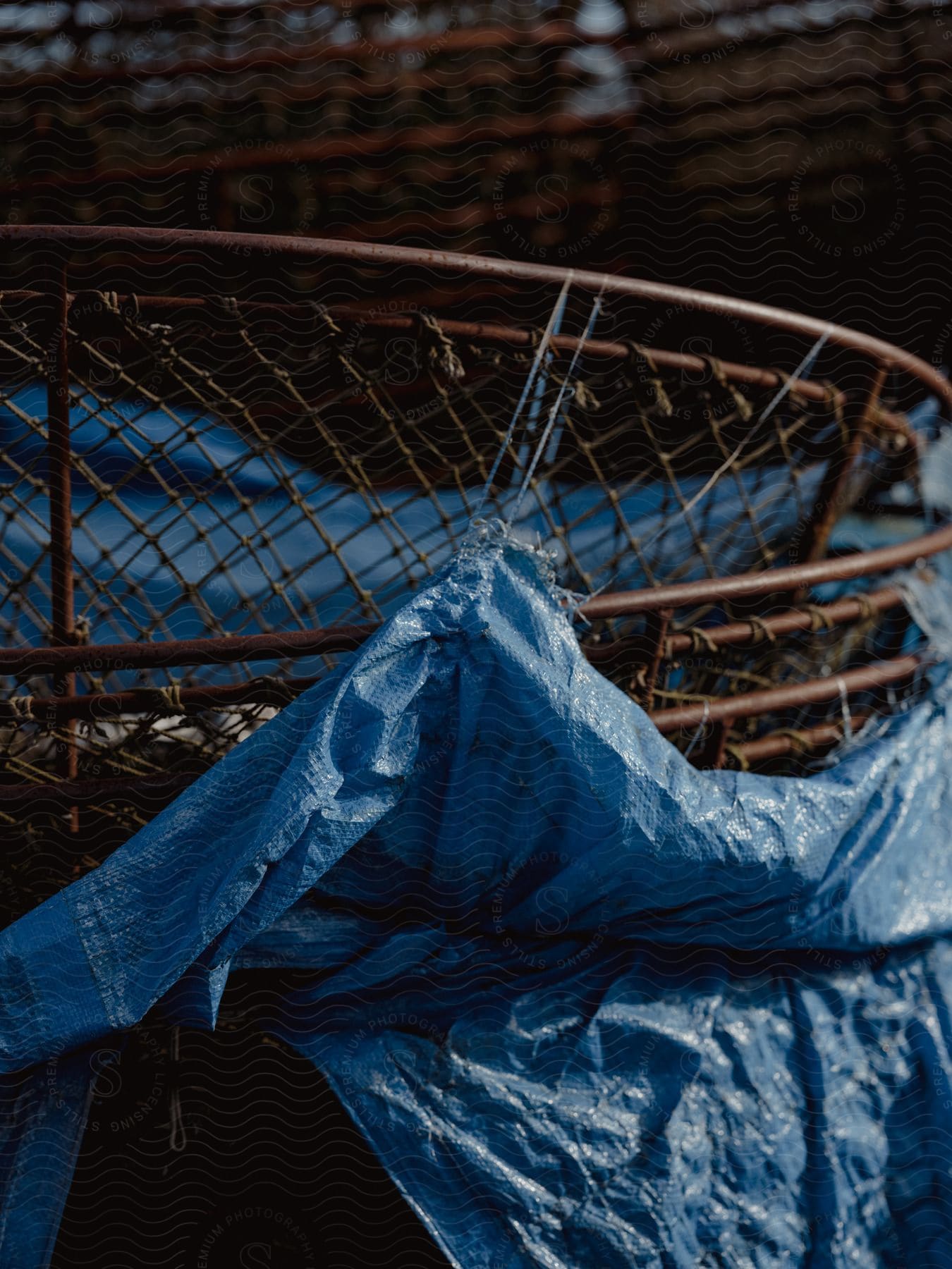 A blue plastic bag attached to a round grid and is hanging by a line