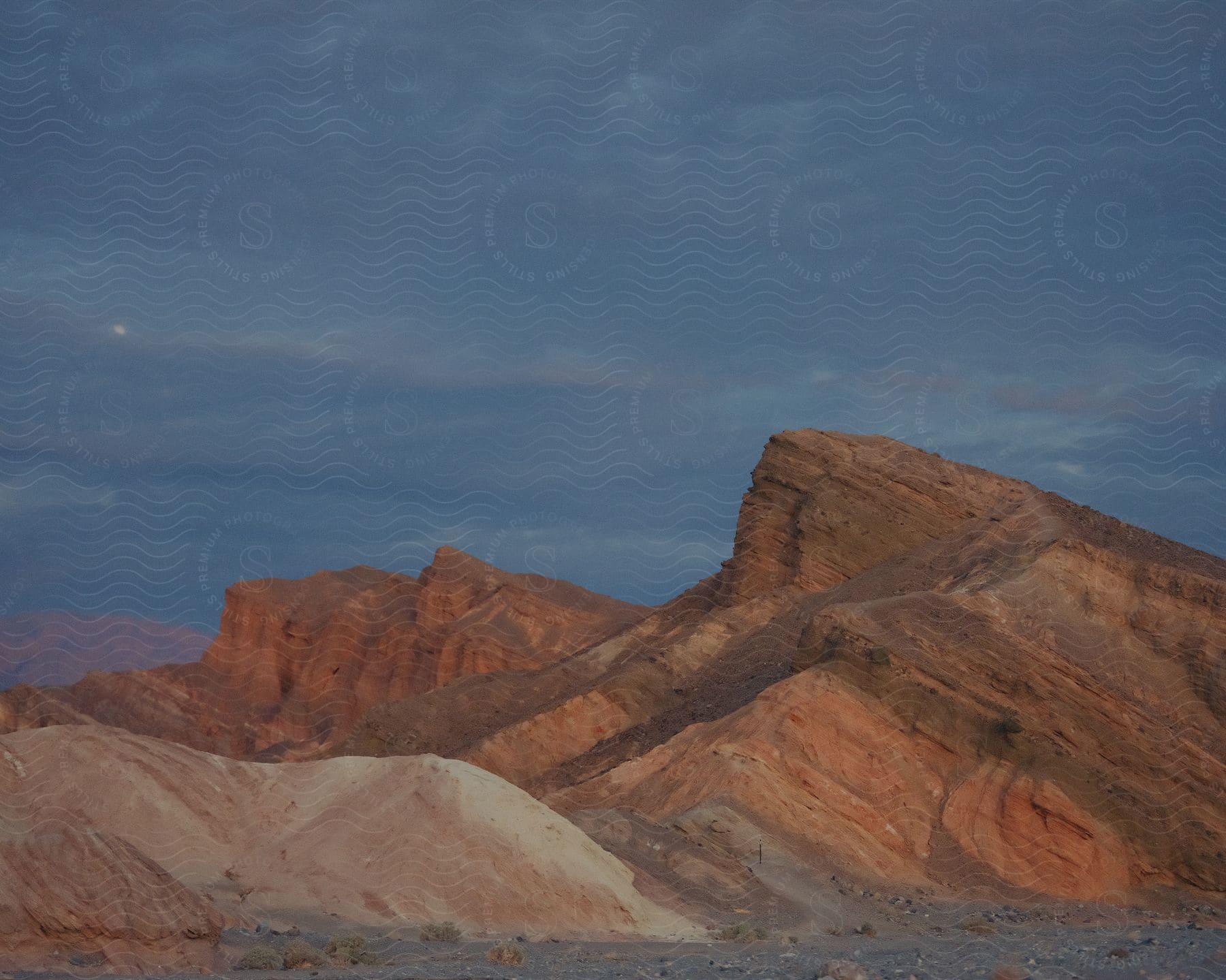 A mountain range of canyons during dusk in the desert.