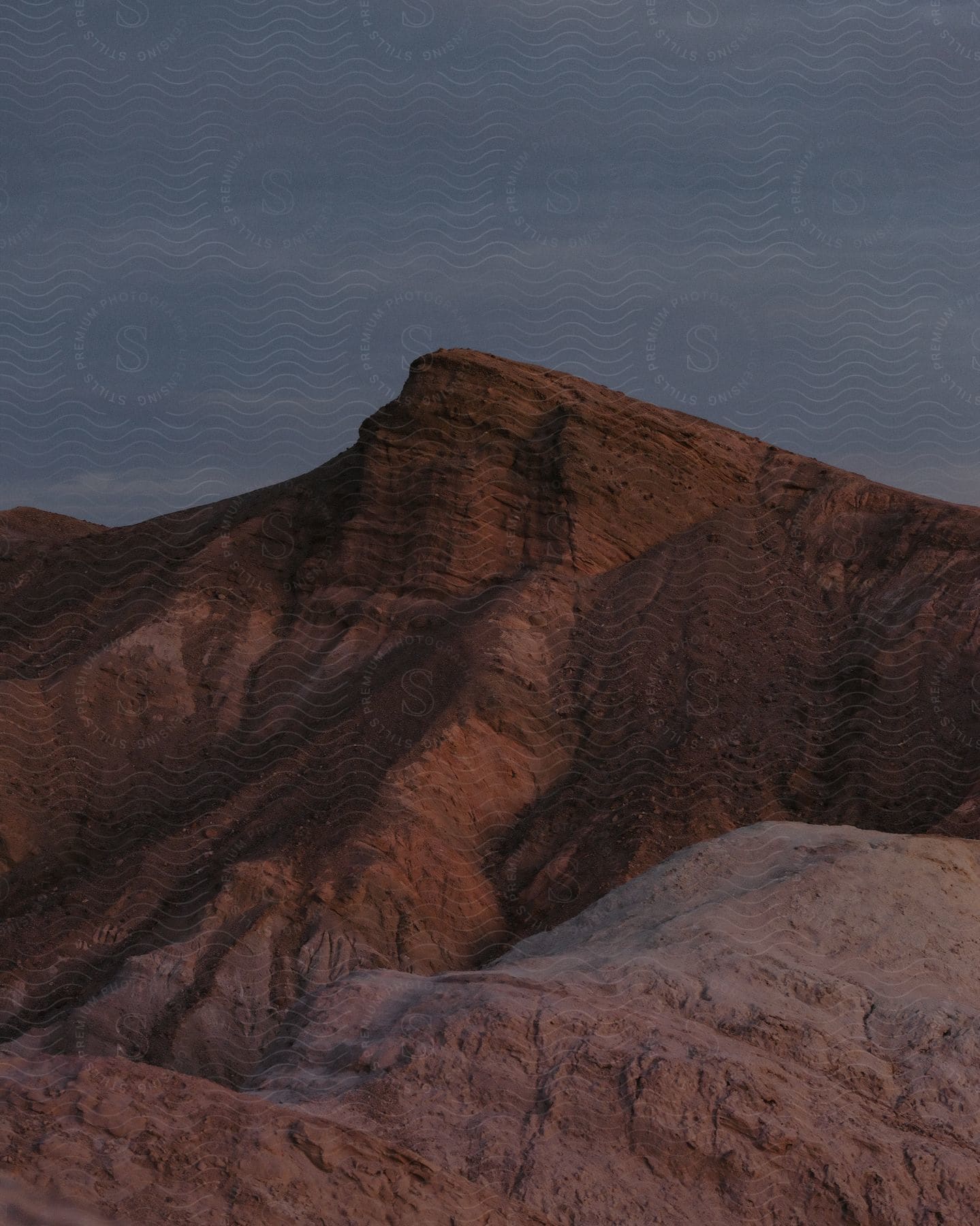 A brown mountain sits against the night sky.