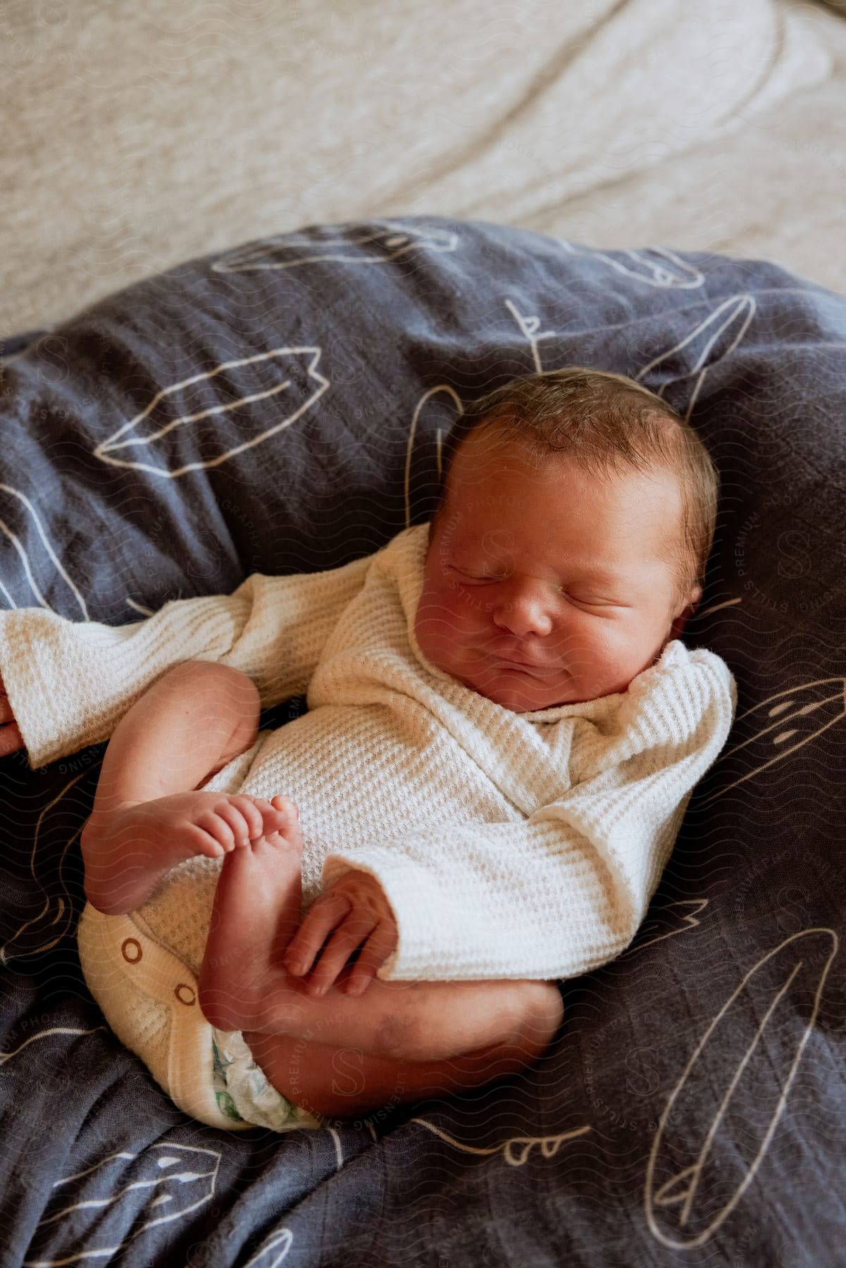 Baby sleeping on a bean bag with a little woolen outfit