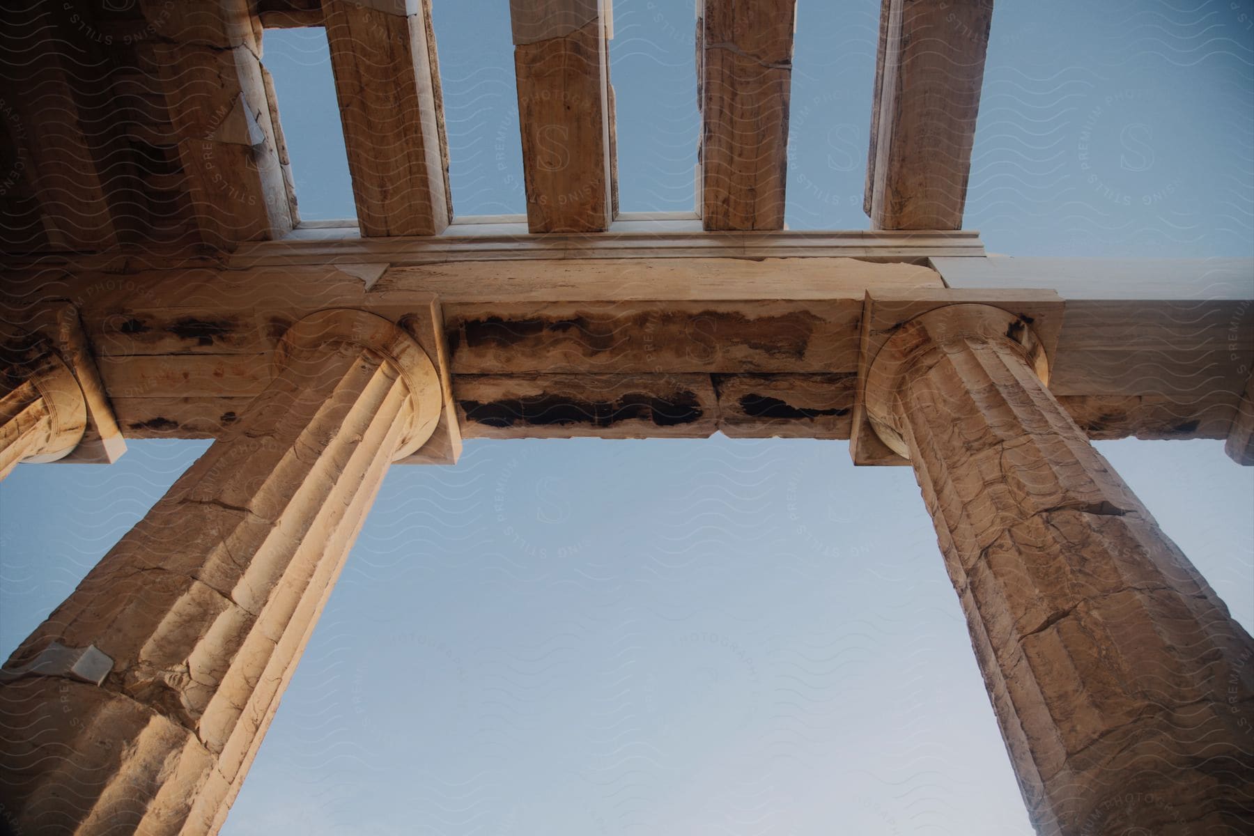 Upward view of ancient columns in vintage architecture.