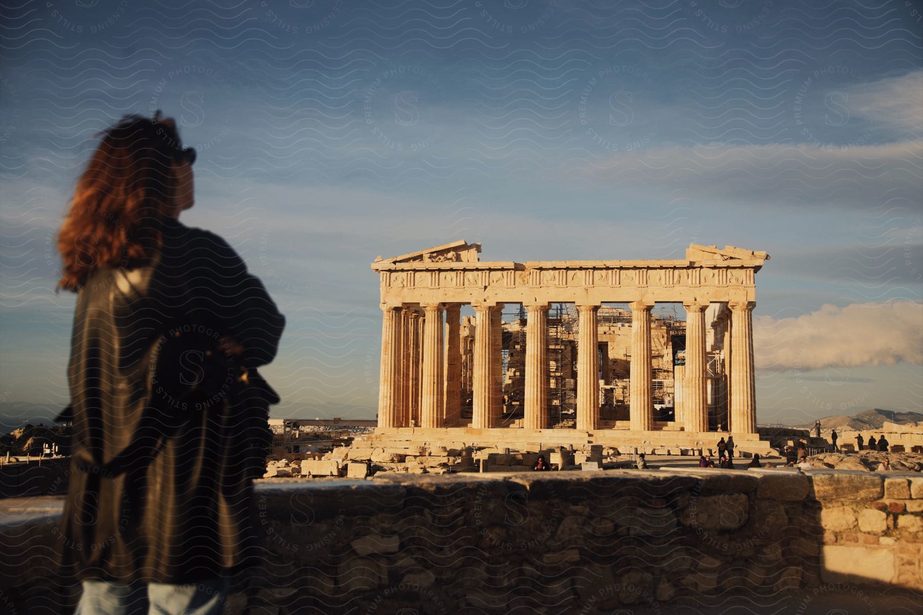 A woman standing outdoors looking at an ancient building