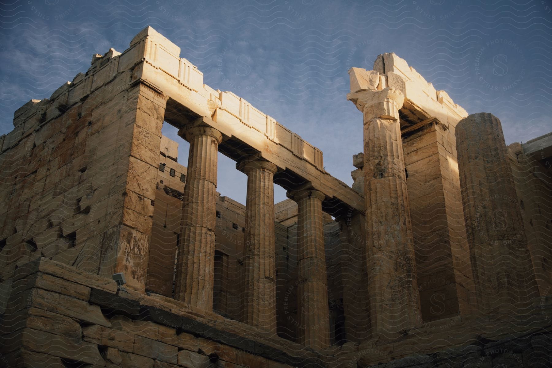 Ruins of the ancient Parthenon stand under a cloudy sky