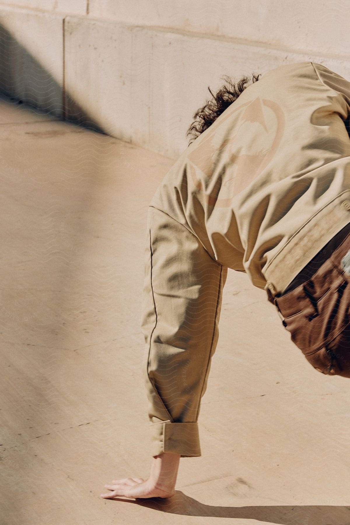 Stock photo of a man dancing outdoors on concrete on a sunny day.