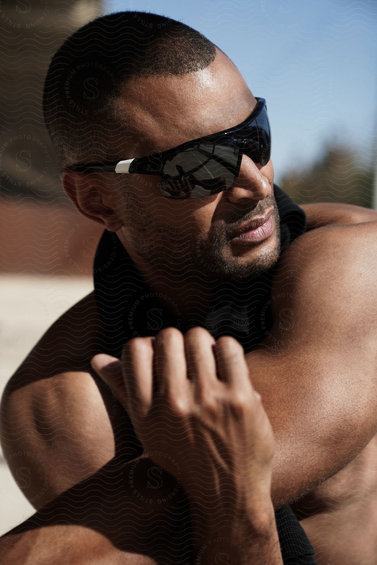 A man wears sunglasses as he sits outside